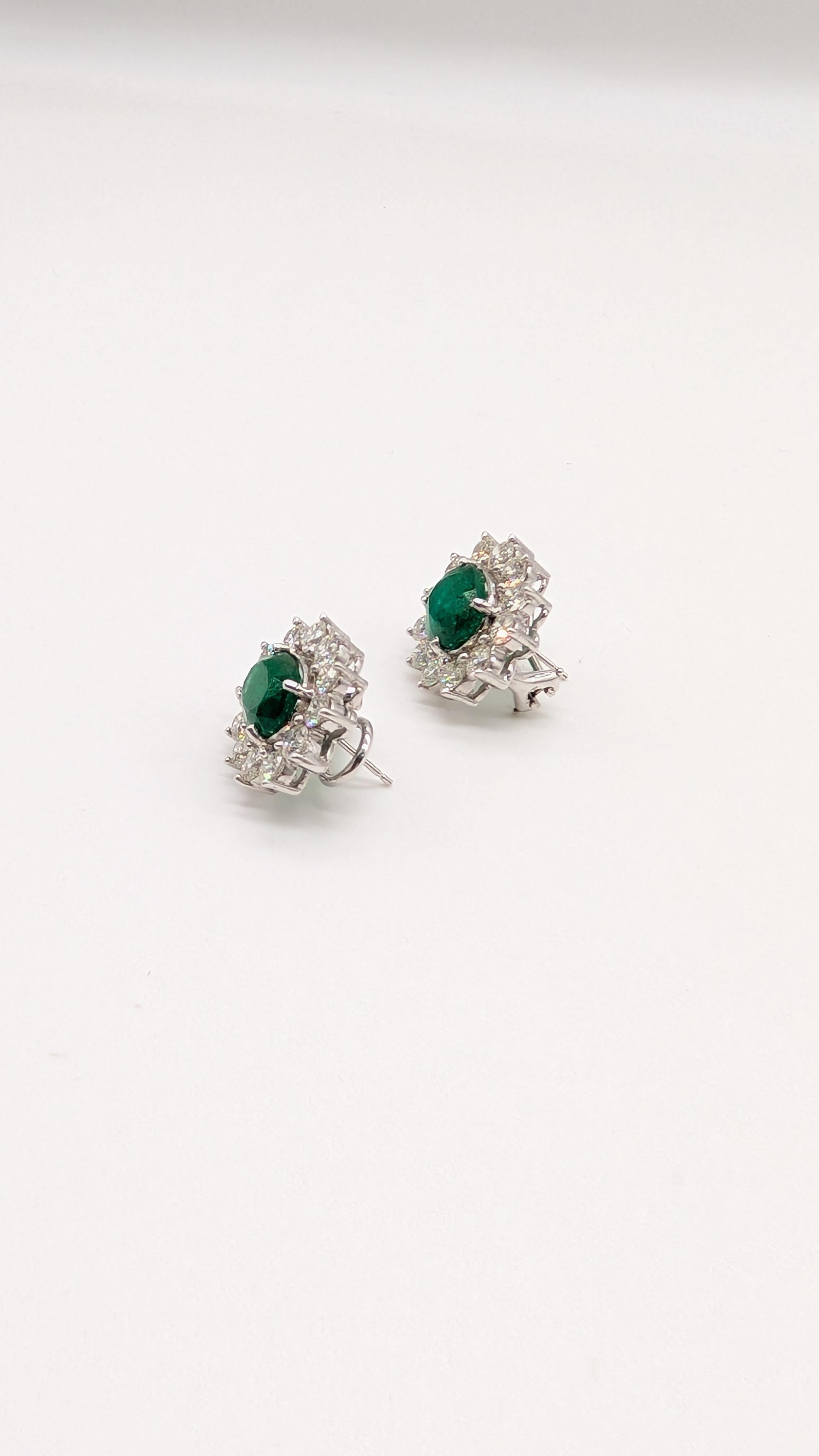 Taille ovale Superbes boucles d'oreilles en émeraude de taille ovale entourée de diamants brillants en vente