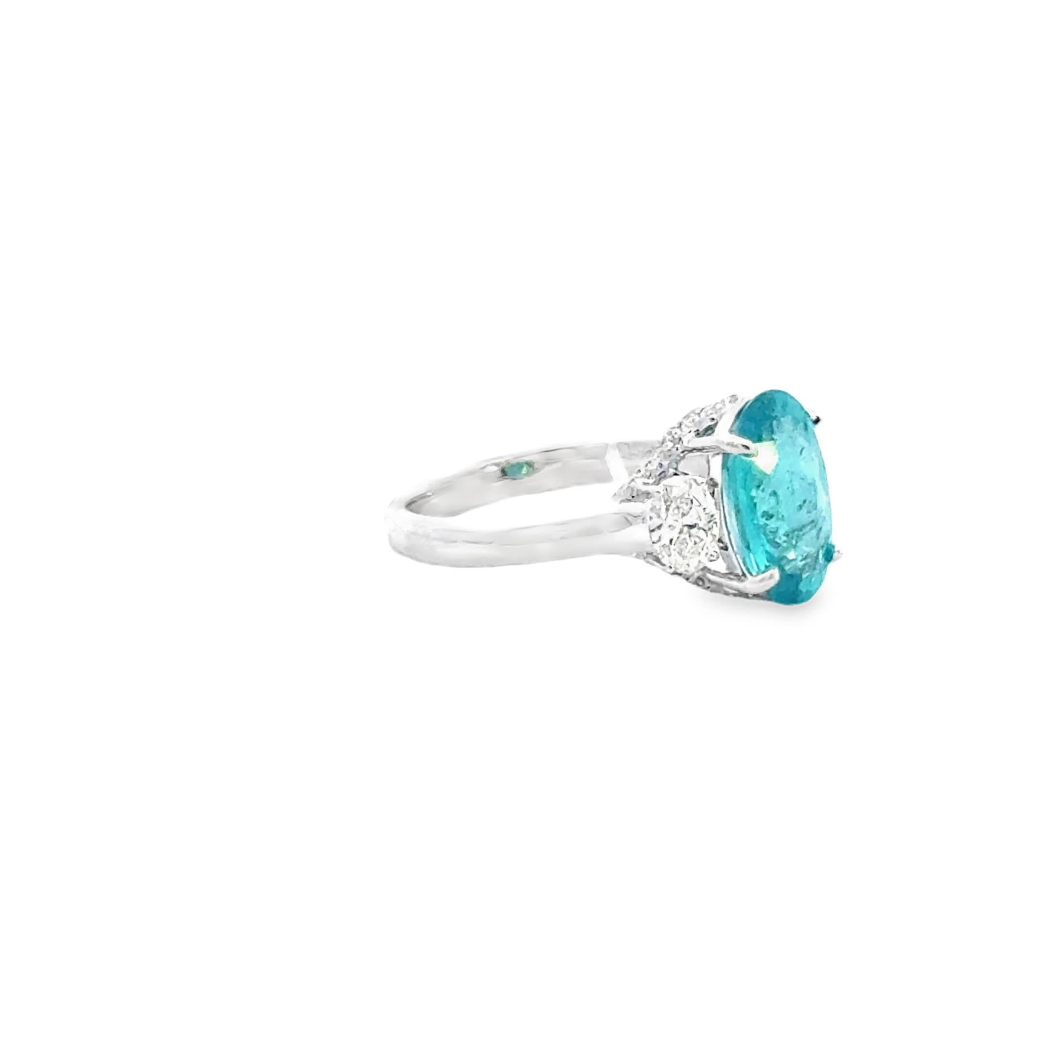 This exquisite ring features a captivating oval Paraiba gemstone, surrounded by sparkling diamonds that enhance its vibrant color. Crafted with precision, it offers a perfect blend of elegance and modern design, making it an ideal accessory for any