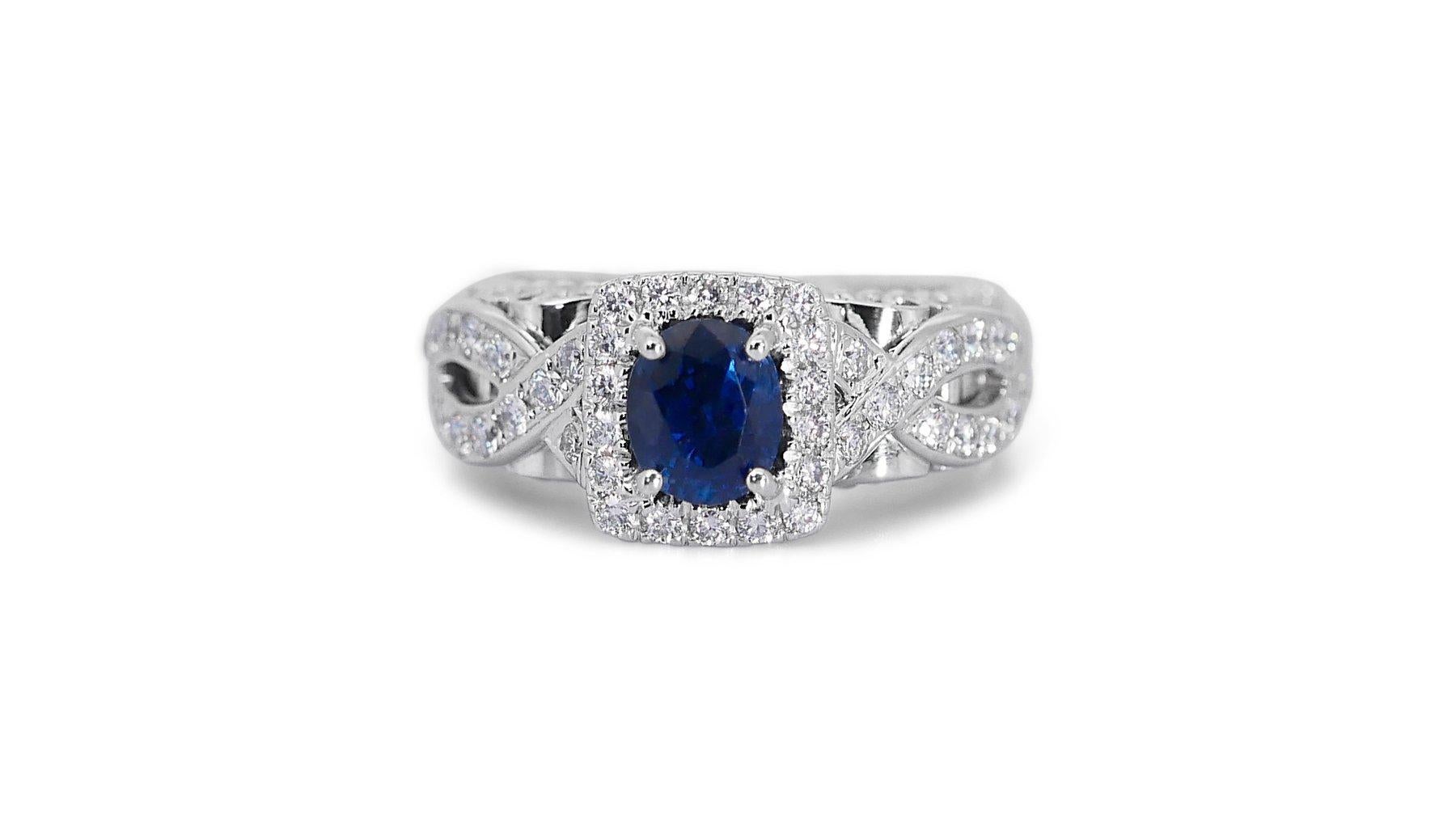 A stunning oval shape natural sapphire ring set in 18K white gold. The center sapphire has a deep blue color and a transparent clarity. It is certified by IGI (certificate number 10J2182023) and weighs 2 carats. The ring is further adorned with 1.27