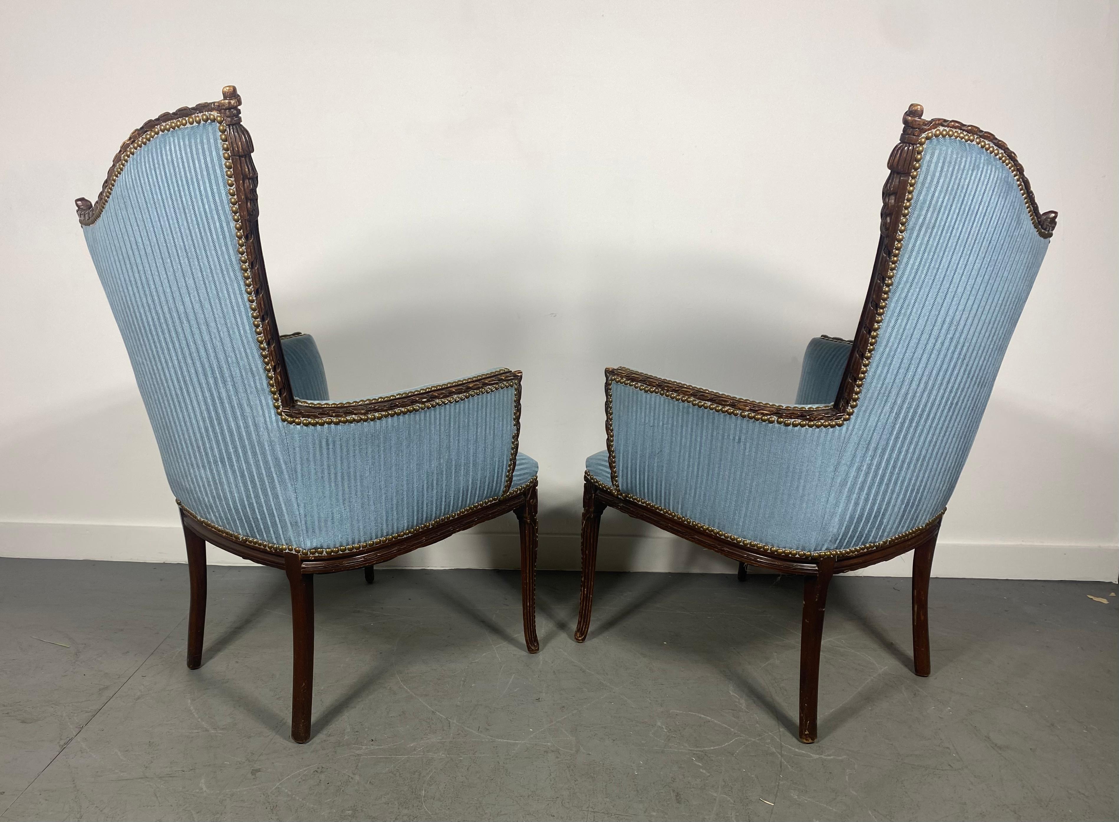 High style pair of arm, lounge chairs by the Grosfeld House Furniture Company. The chairs feature hand carved wood frames with decorative tassels etc.Age appropriate wear to wood, Glamorous and chic design, nice condition, recently reupholstered.
