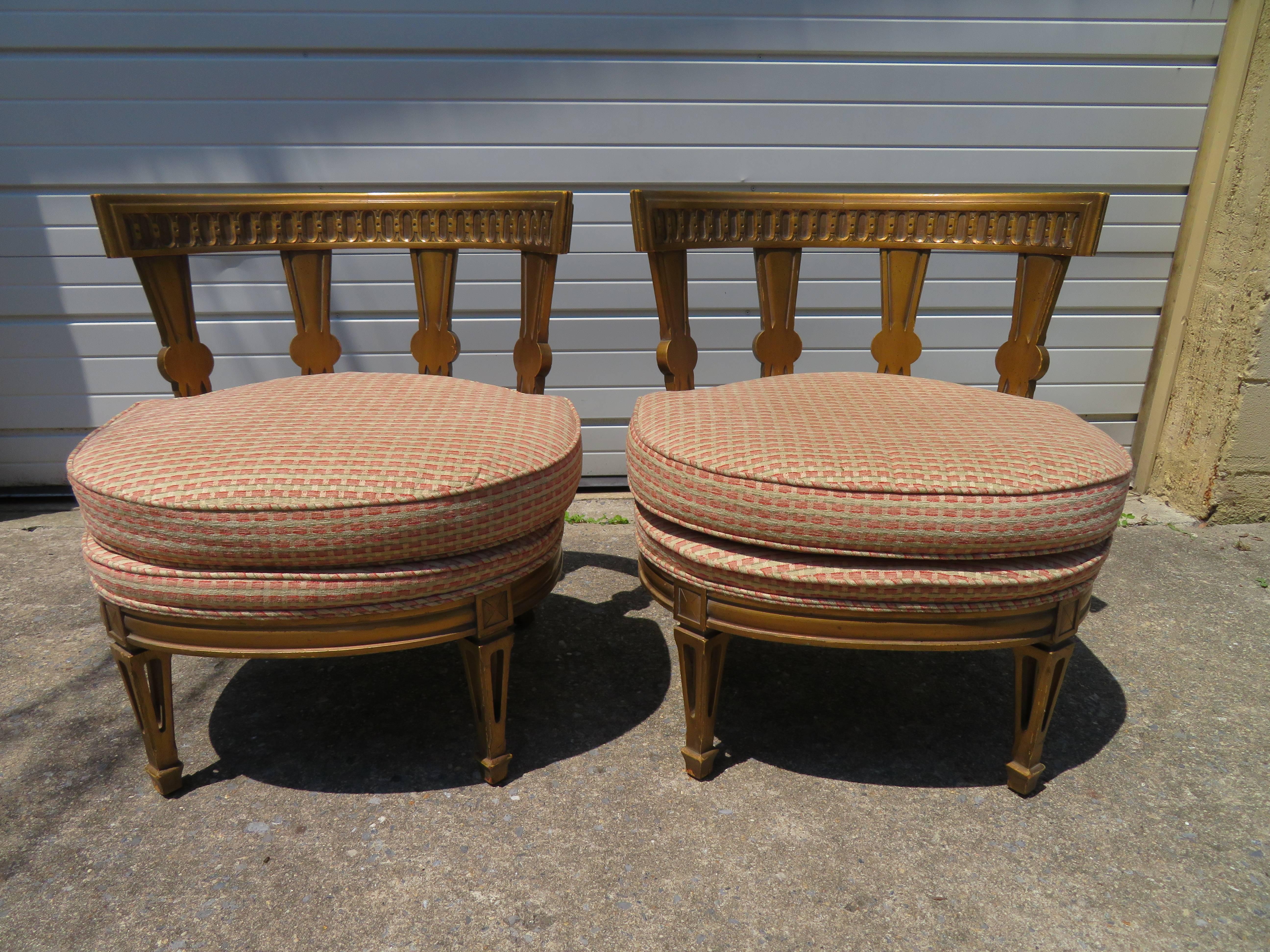 Stunning pair of Hollywood Regency Maison Jansen style slipper chairs. Chairs have well carved frames with classical details to the backs and legs. The distressed gold finish-adds tremendous vintage charm.