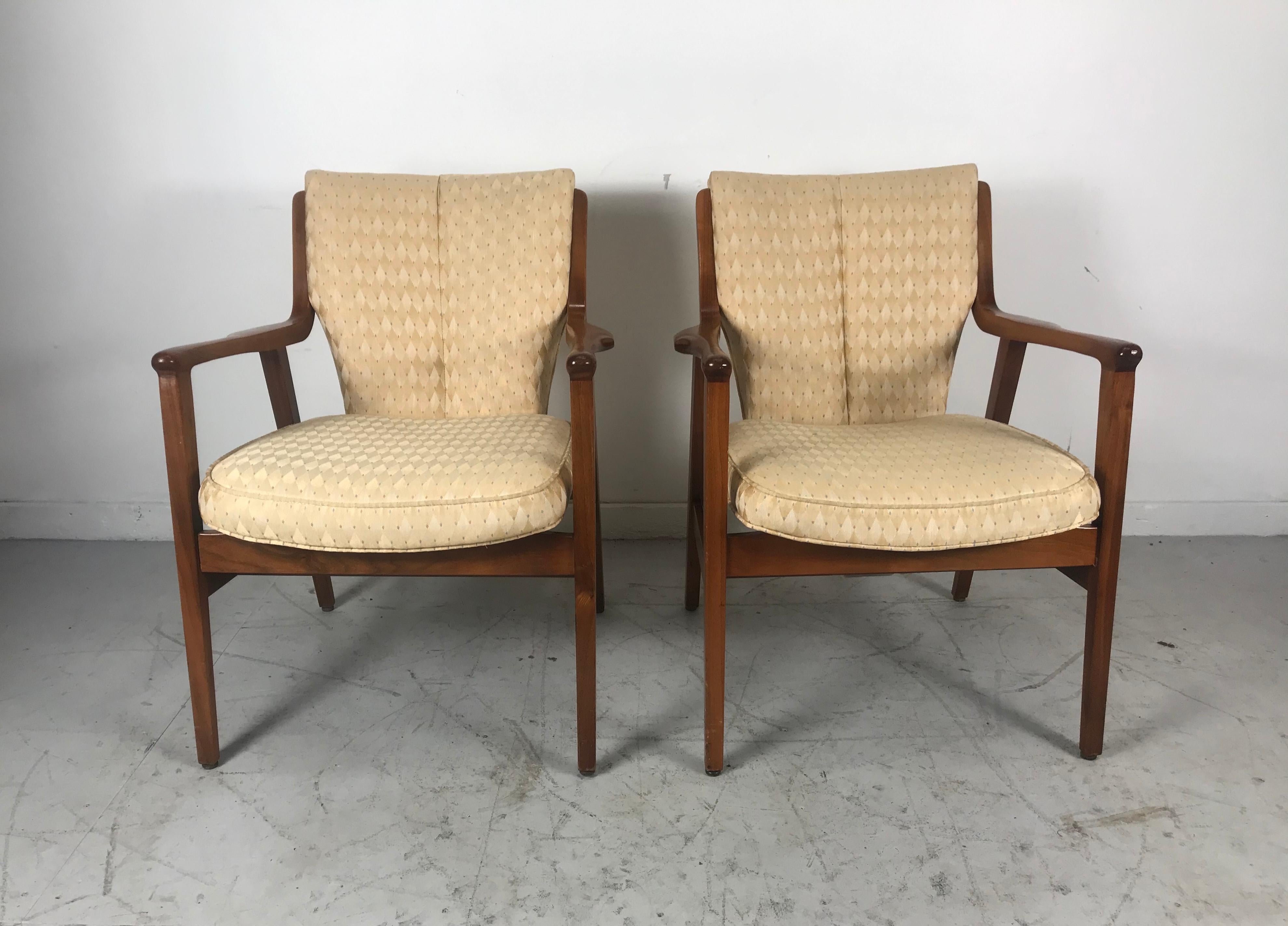 Stunning pair of Modernist lounge chairs by Gunlocke, manner of Finn Juhl, unusual split back design, Sculpted walnut frames recently reupholstered in a neutral tone harlequin pattern fabric. Extremely comfortable, solid, sturdy quality and