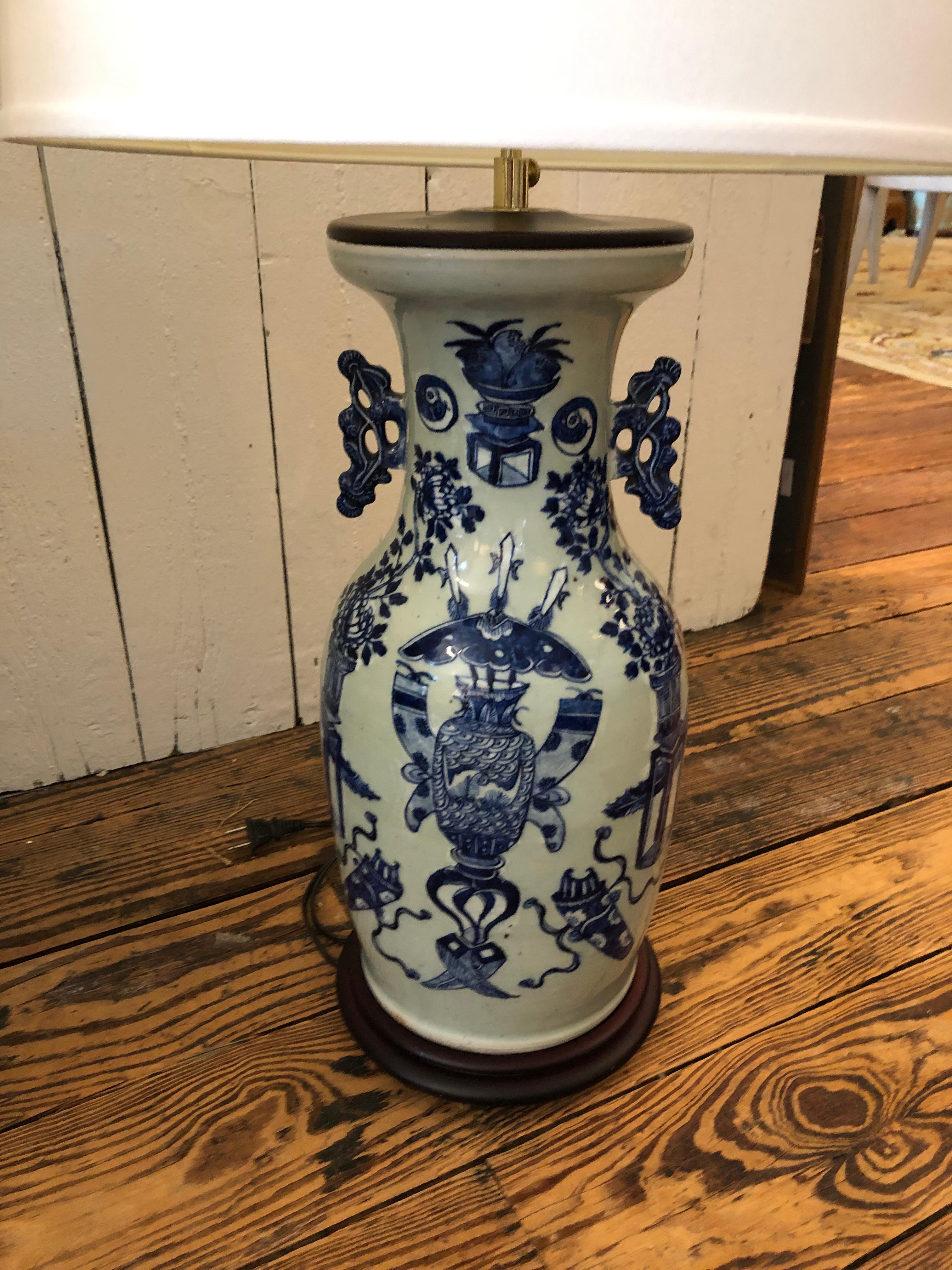 Handsome large pair of slightly different blue and white Chinese vase shaped antique table lamps having lovely decoration and wooden bases. Vases are 18.25 h
One lamp is 32.5 h; the other 30.5 probably due to harp differences
Bases are 8