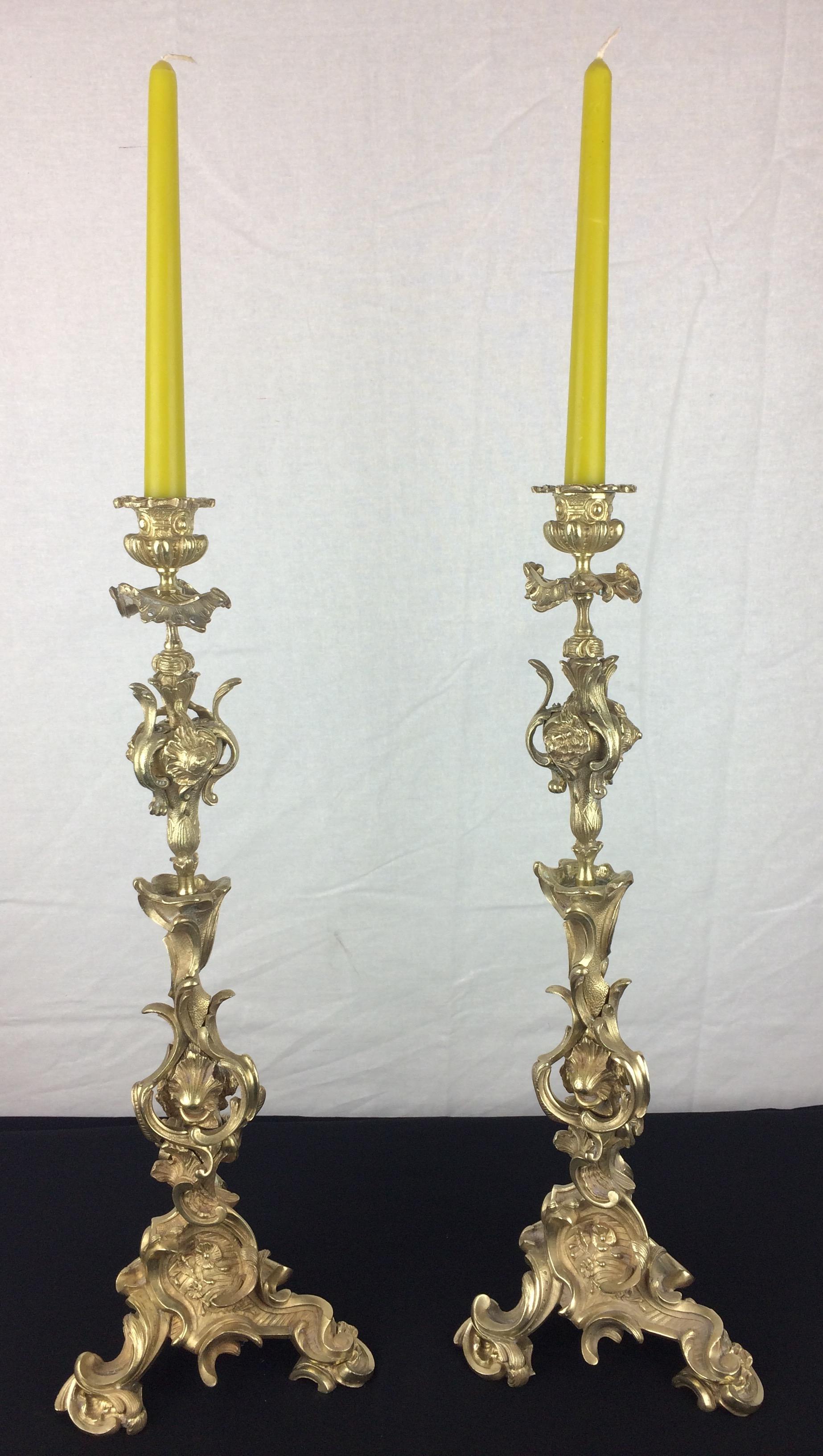 A very fine pair of 19th century French Napoleon III gilt bronze candelabras, each with scrolled arms, crowned with a bronze candle snuffer in the shape of a burning flame. 

Each bears the signature or makers mark, Raulin.
  