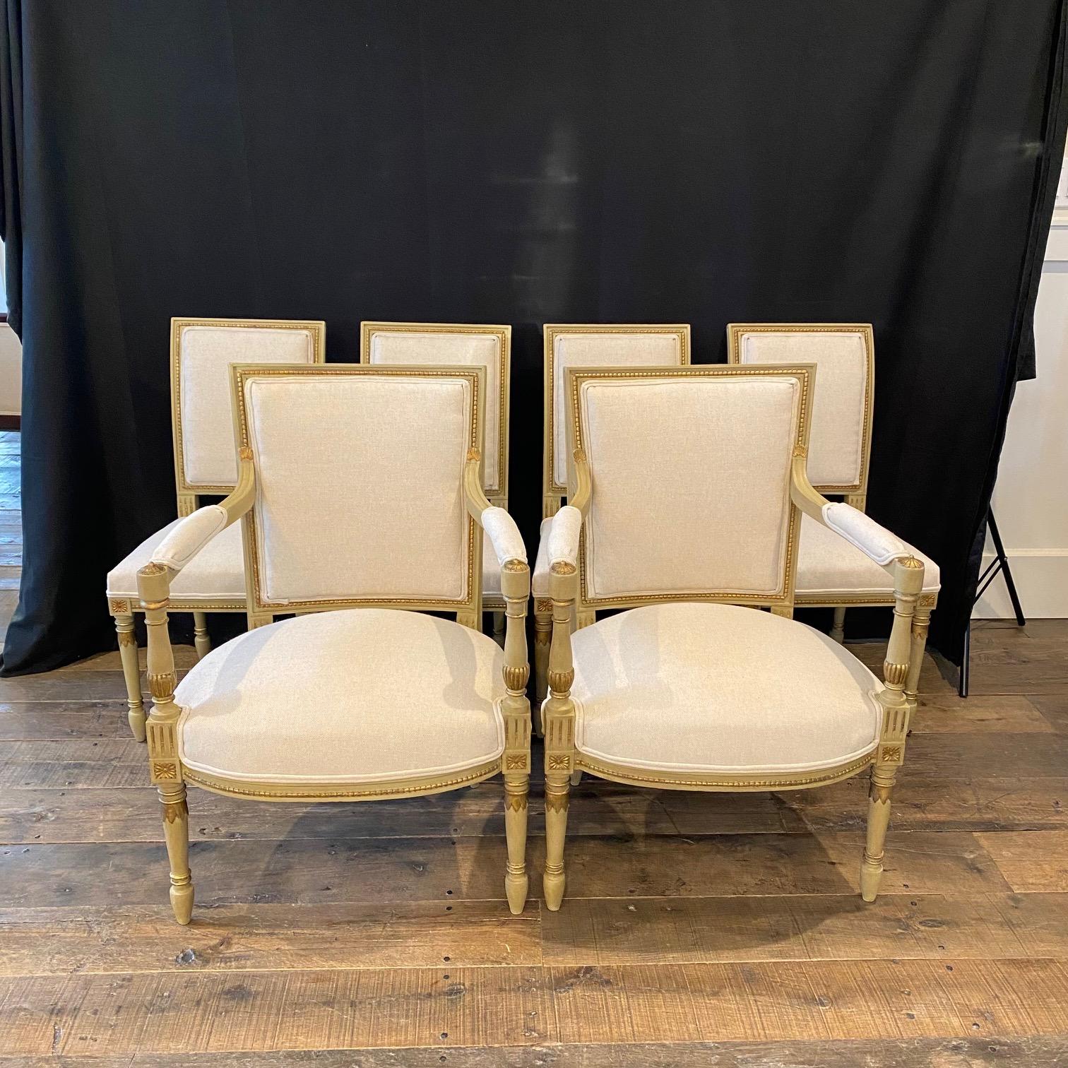 These French Louis XVI chairs have an elegant silhouette and a carved wooden frame newly upholstered in a high quality British cotton/linen neutral fabric. The chairs have a square backrest and seat carved with classicizing details. The gold gilt