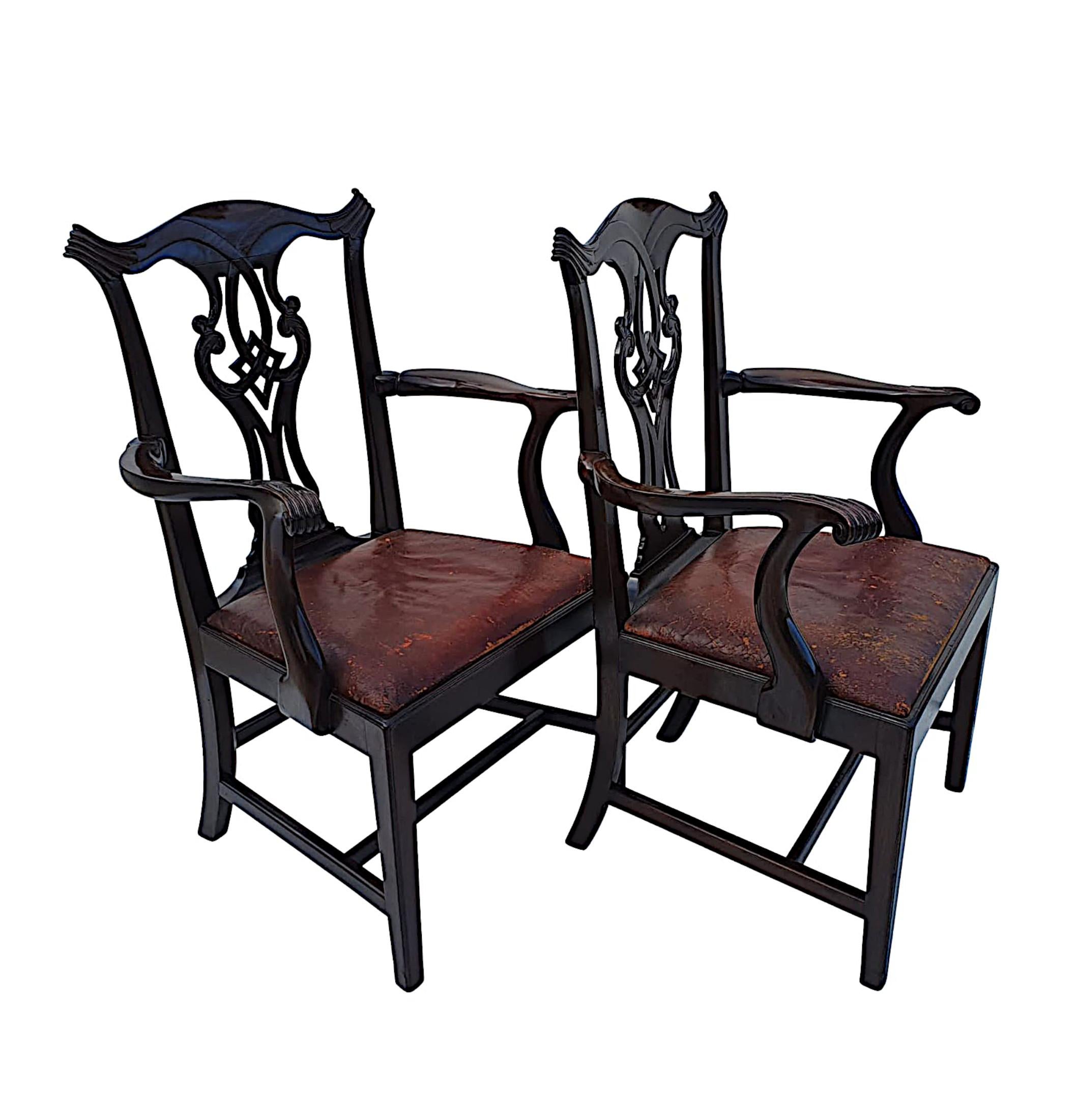 A stunning pair of 19th century Georgian design mahogany open armchairs in the manner of Chippendale. Stunningly hand carved with a lovely patina, the bow shaped top rail with fluted corners is raised over a beautiful pierced interlocking back splat
