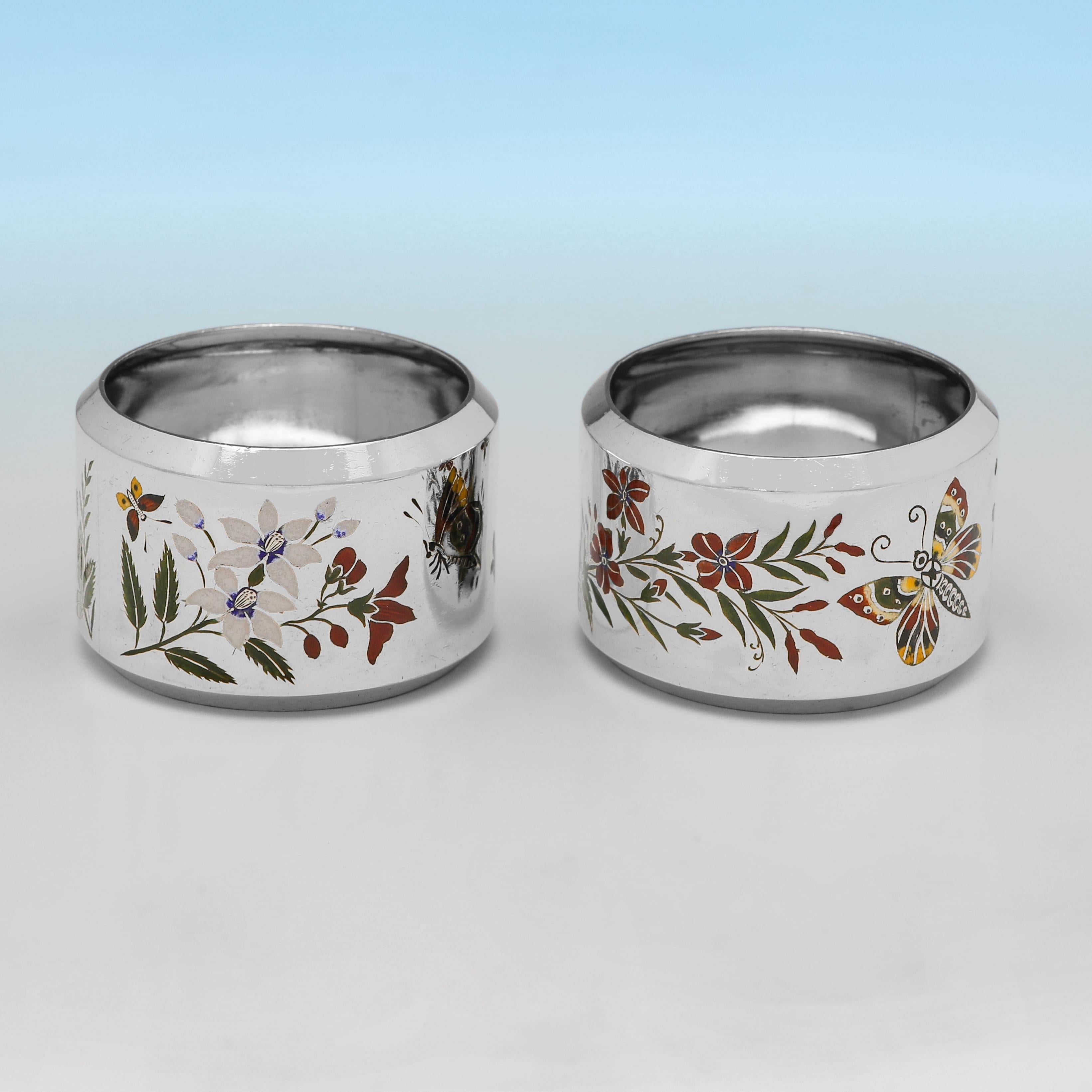 Poinçonnée à Birmingham en 1880 par Elkington & Co, cette très jolie paire de ronds de serviette anciens en argent sterling de l'époque victorienne présente une décoration émaillée dans le goût esthétique, chaque rond de serviette étant orné de