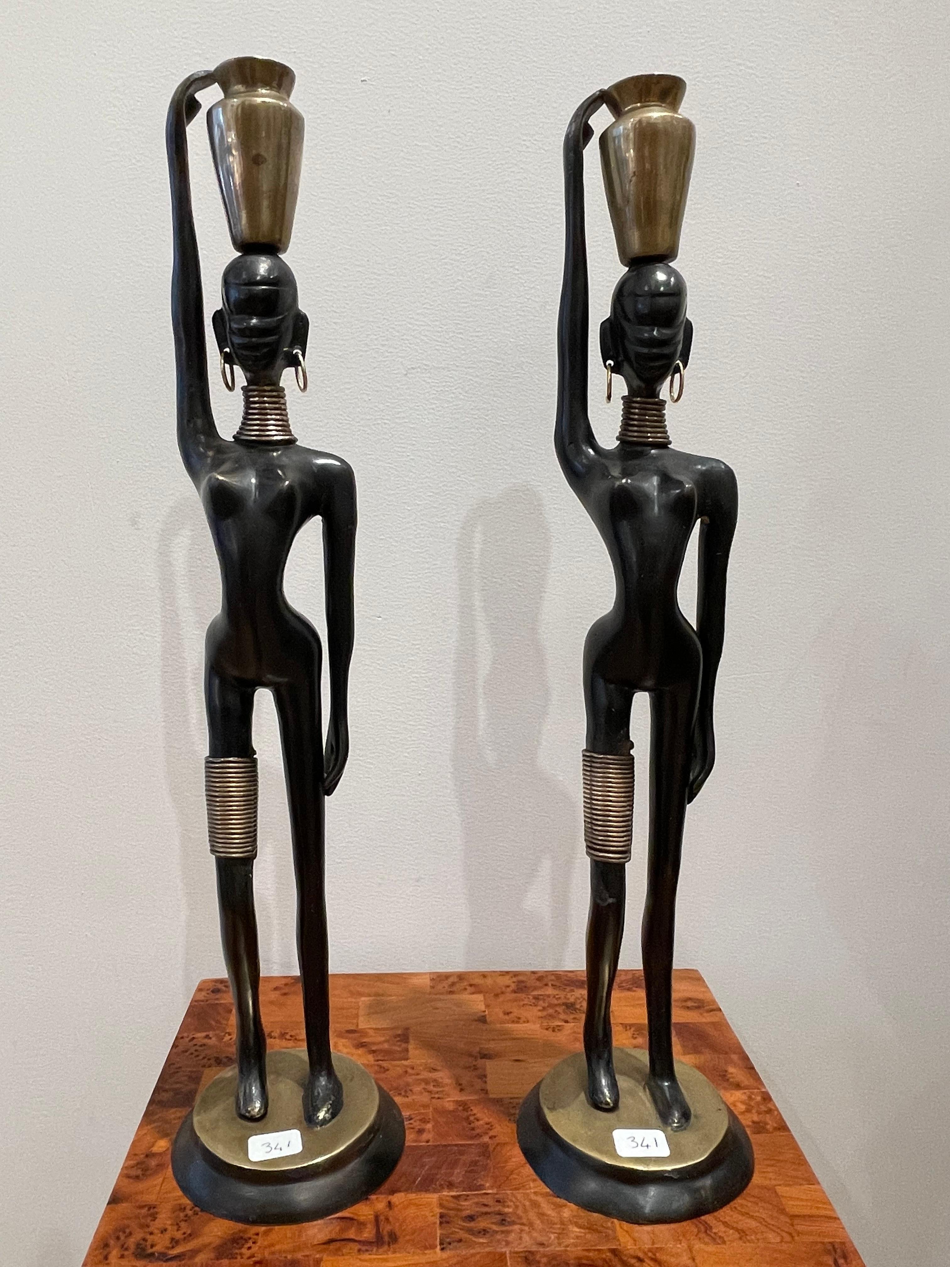 Stunning pair of African lady carrying water, in the style of Karl Hagenauer 1970’s,
Bronze with double black and gilt patina,
Dimensions : 45 cm / 17.72 inches
Stunning pair of African women carrying water. The woman's body is stylized with elegant