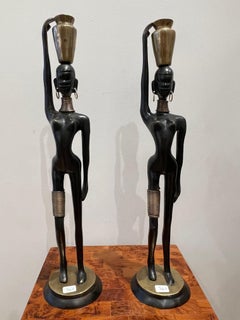 A pair of women carrying water, in the style of  Hagenauer 1970