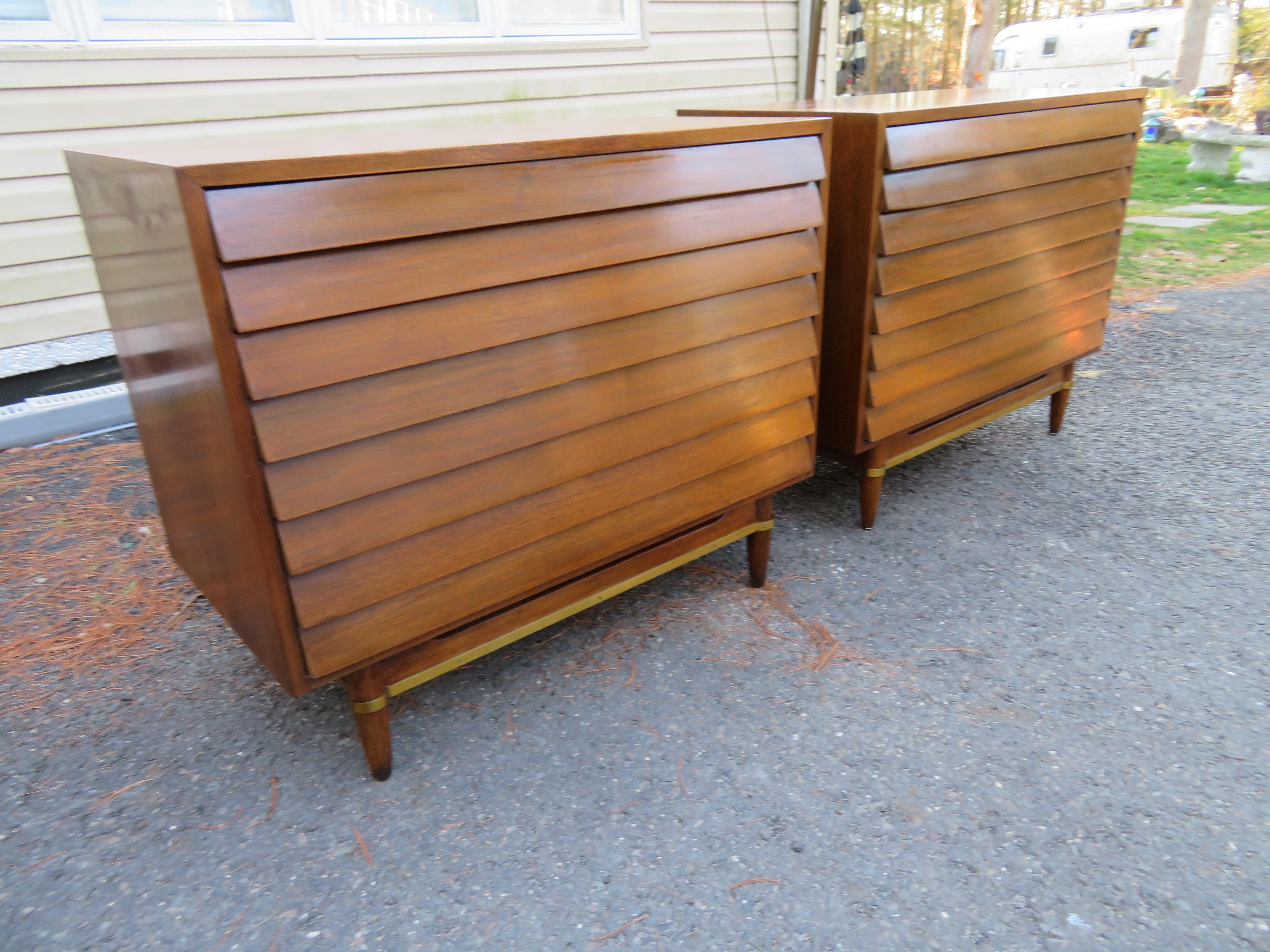 Stunning pair of American of Martinsville louvered walnut bachelor’s chests. We love the stylish louvered drawer fronts and handsome brass banding along the base. These wonderful chests measure 30