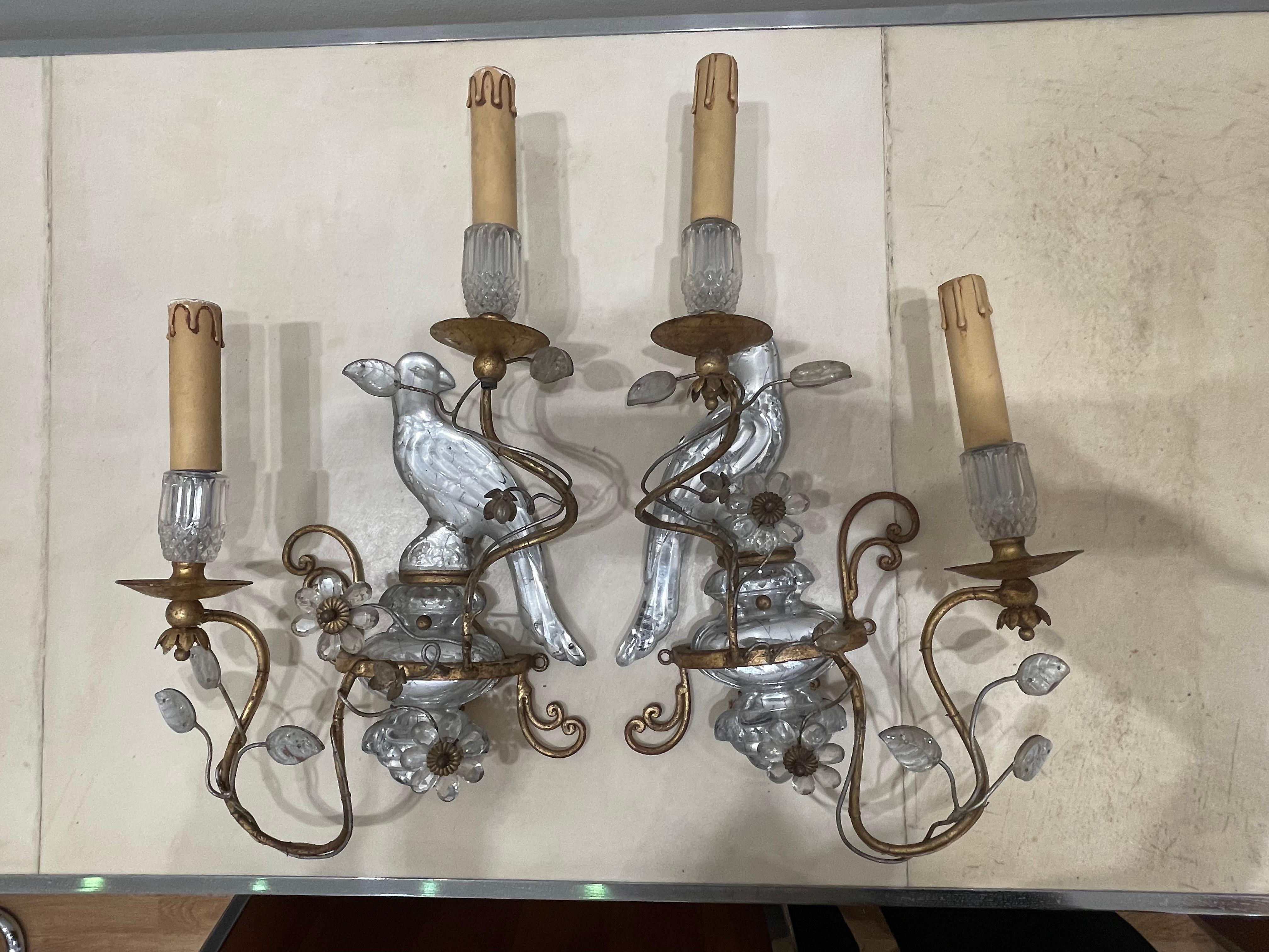 Stunning pair of sconces by Maison Baguès (Paris). This model with the parrots is iconic and made Maison Baguès famous and successful. They are ancient : circa 1930's-1940's and in good condition.
Two lights per sconce. Decorative motifs (parrots,