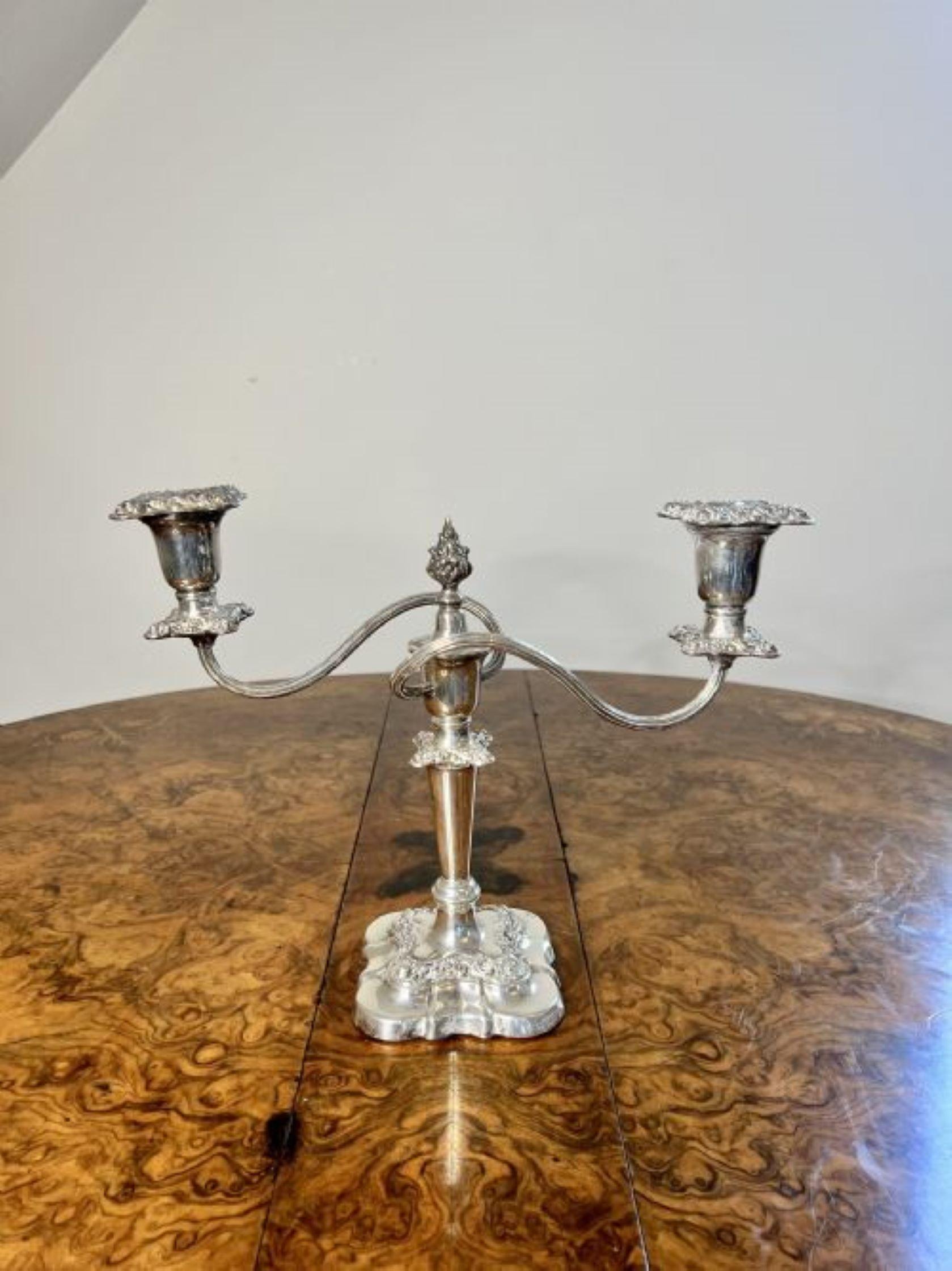 Stunning pair of antique Edwardian silver plated ornate candelabras having a stunning pair of antique Edwardian silver plated candelabras with two light branches above a shaped column standing on square ornate bases.