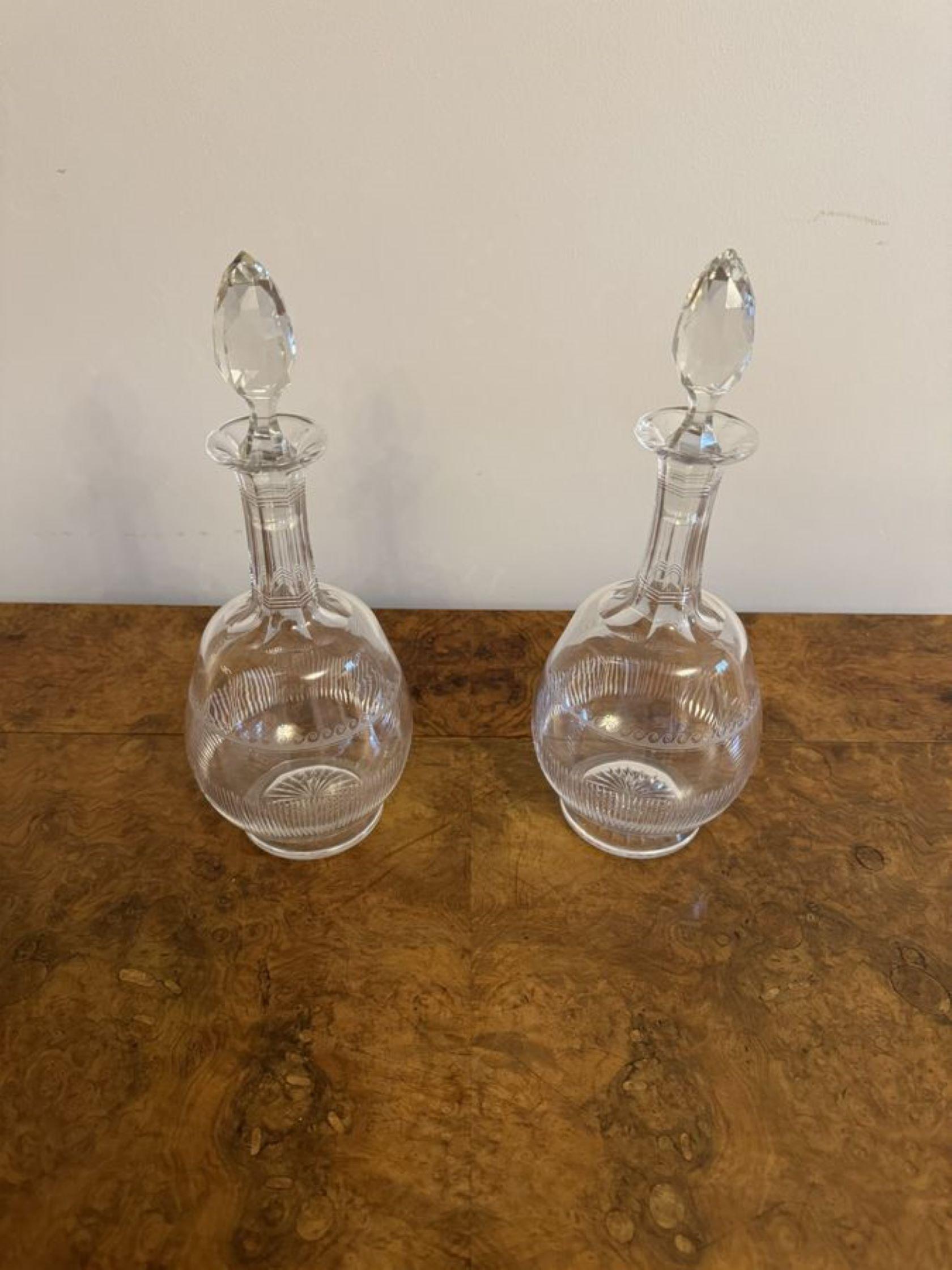 Stunning pair of antique Victorian decanters, having a quality pair of Victorian decanters with etched and cut glass detailing, raised on a circular shaped base, with cut glass stoppers. 

D. 1880