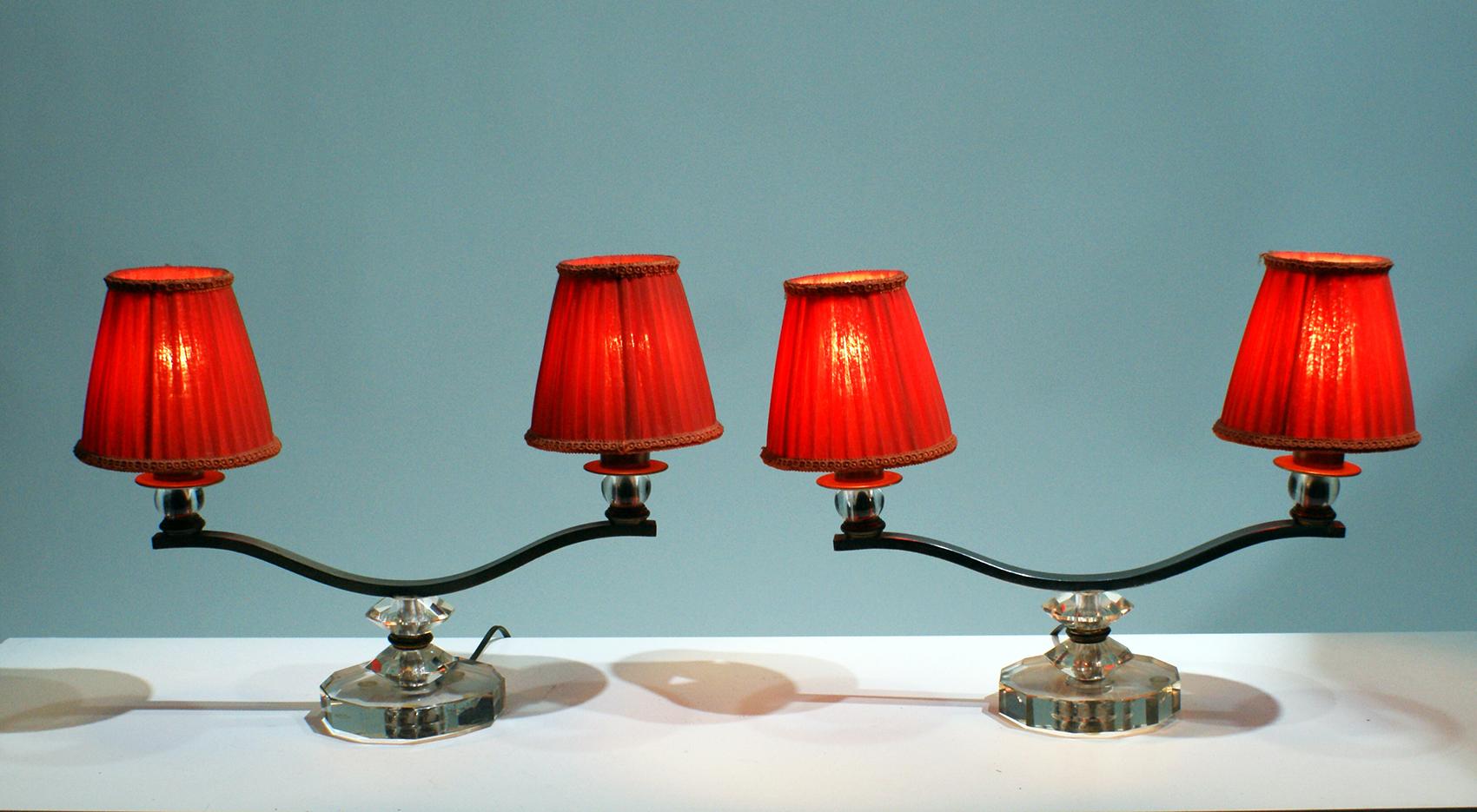 Pair of Art Deco table lamps, having two arms of lights in silver metal bronze, resting on geometric Plexiglass motif, supporting two pleated “bistro” shape lampshades in orange linen fabric.
Lovely when the lights on. Beautiful in living or dining