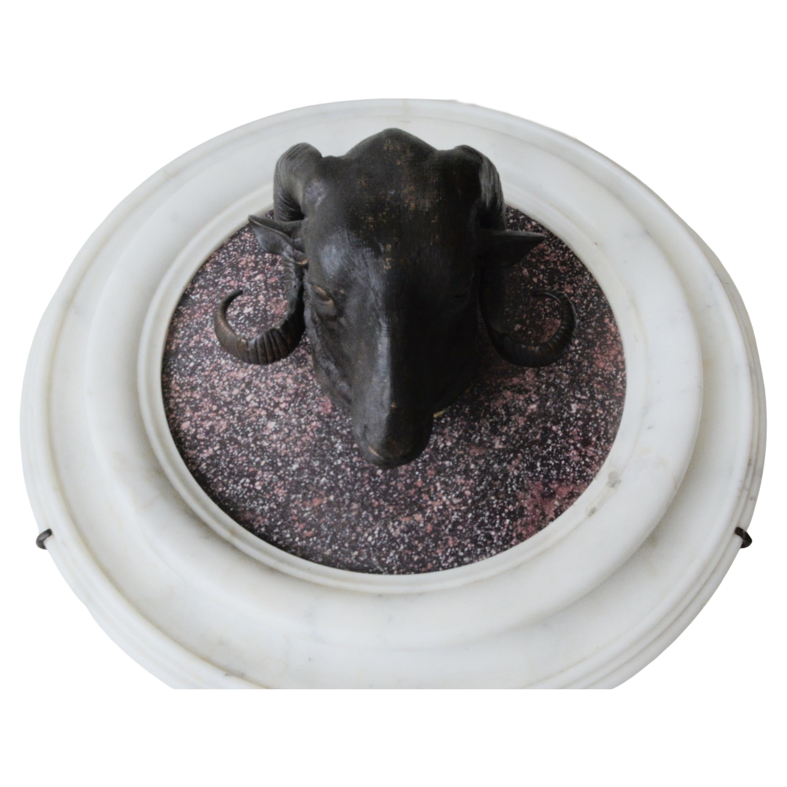 Beautiful Pair of patinated bronze rams' heads on porphyry and white marble mounts.


