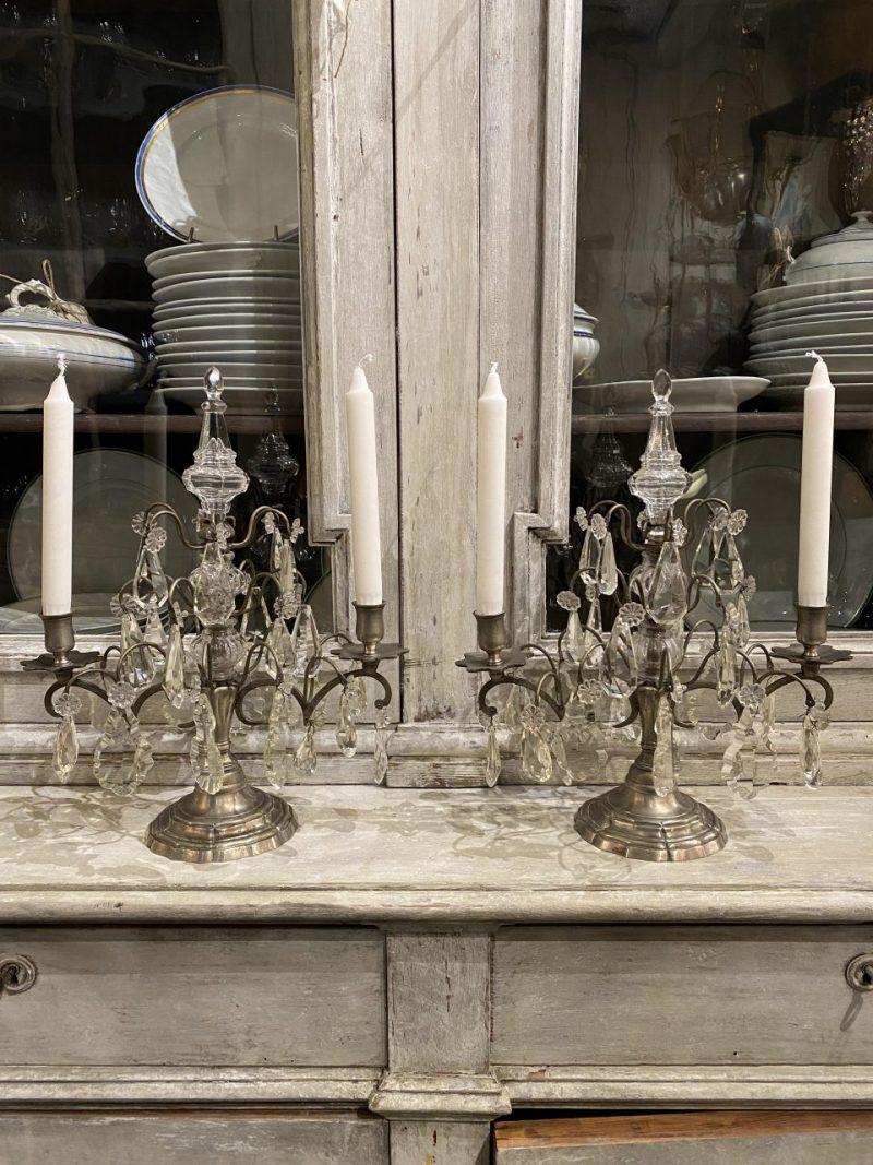 A lovely pair of imposing old candalabras, known as ‘girandoles’ in French. Beautifully nickeled brass, and ornately decorated with crystal prisms, from circa 1900. They both have two arms with candle holders for traditional candles, and are