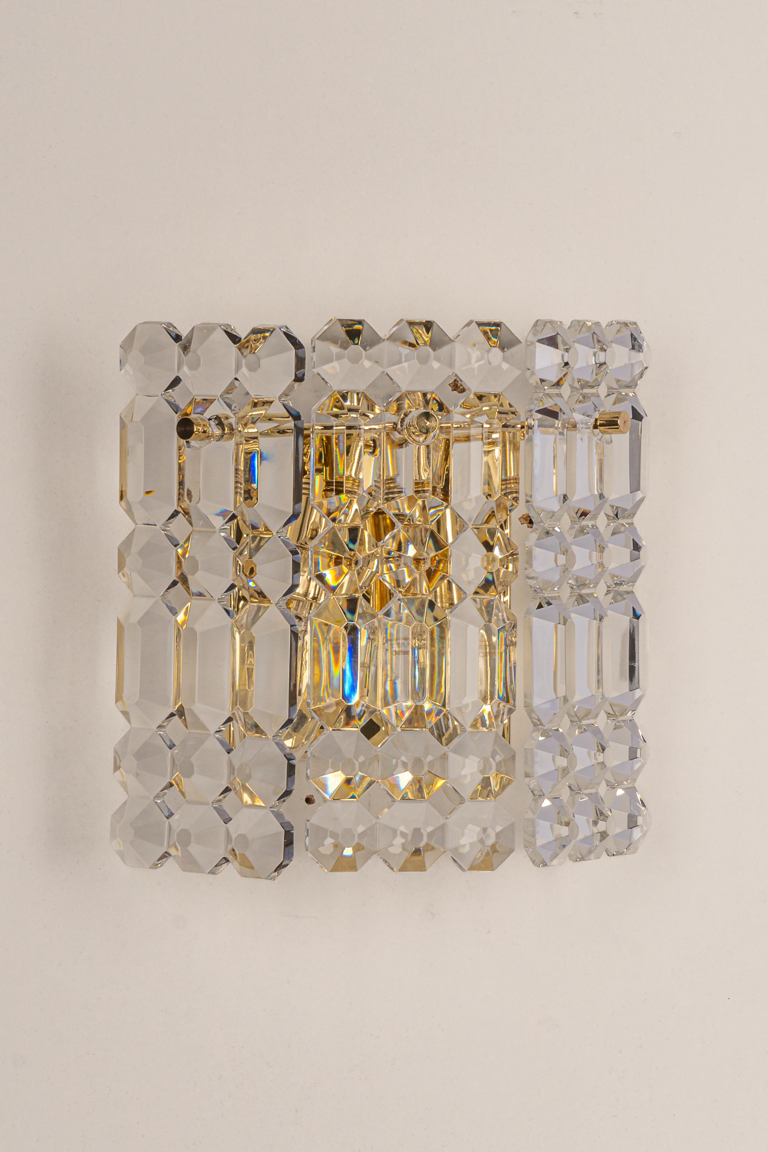 A stunning pair of golden sconces with crystal glasses, made by Kinkeldey, Germany, circa 1970-1979. It’s composed of crystal glass pieces on a brass frame.

Best of the 1970s from Germany.
High quality and in very good condition. Cleaned,