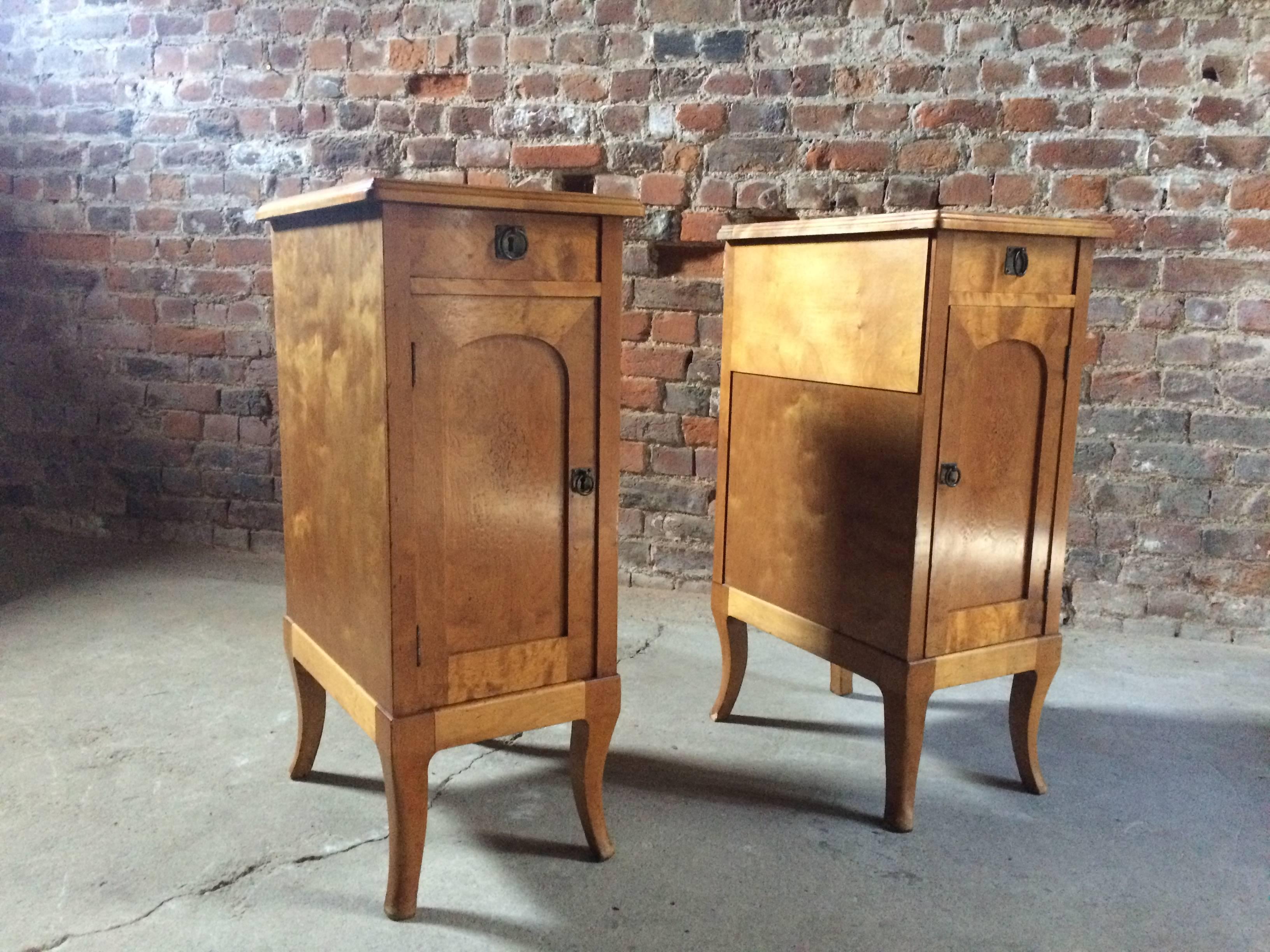 A stunning pair of early 20th century French satinwood bedside table cabinets in the Art Nouveau style. The rectangular top over a short freize draw above a single cupboard door with individual drawers within. Each cupboard door with intricate