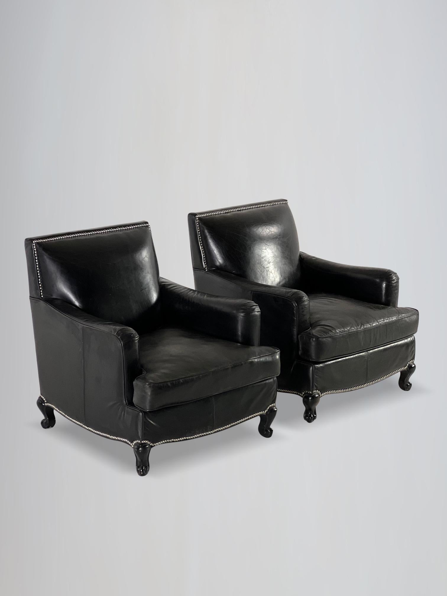A stunning pair of 20th century French quality leather and ebonised wooden upholstered black leather club armchairs. Retaining the original leather and studs, square back, having shaped arms with deep and roomy proportions sitting, loose feathered