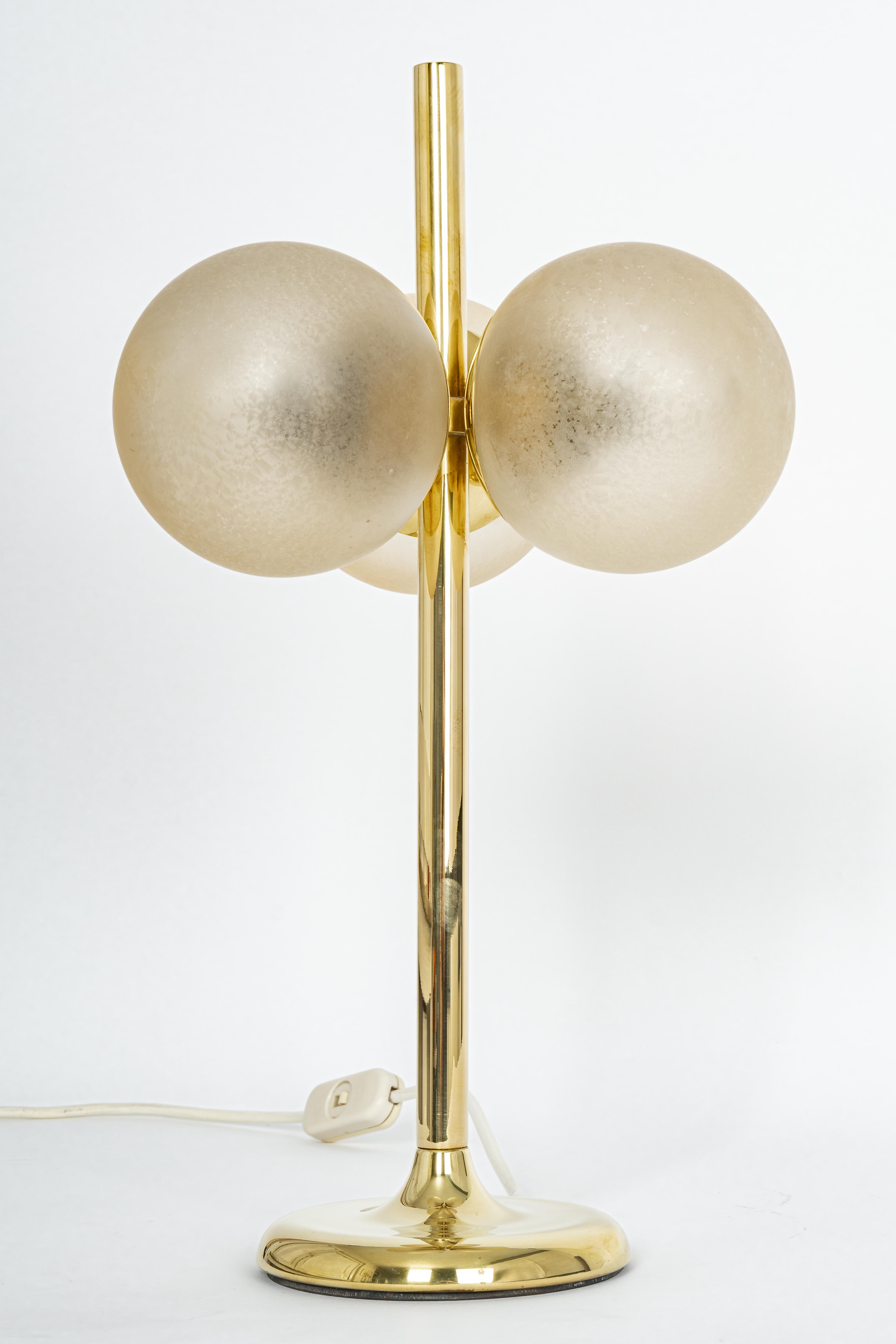 Stunning pair of large brass table lamps by Kaiser, Germany, 1970s
It’s composed of three light brown art glass pieces on a brass frame.

High quality and in very good condition. Cleaned, well-wired and ready to use. 

Each table lamp requires