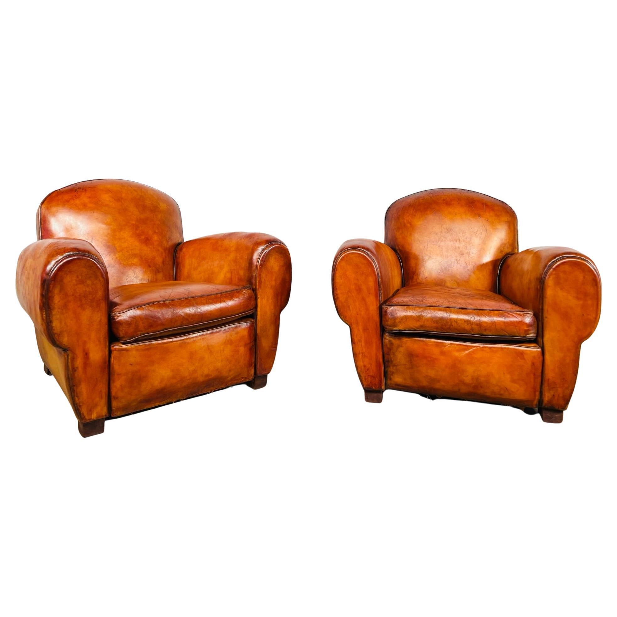 An exceptional pair of french club chairs, well sprung seats with long cigar shaped arms these chairs are comfortable to sit in.

They have a fantastic patinated cognac colour and the leather has a great Finish and patina, some superficial marks