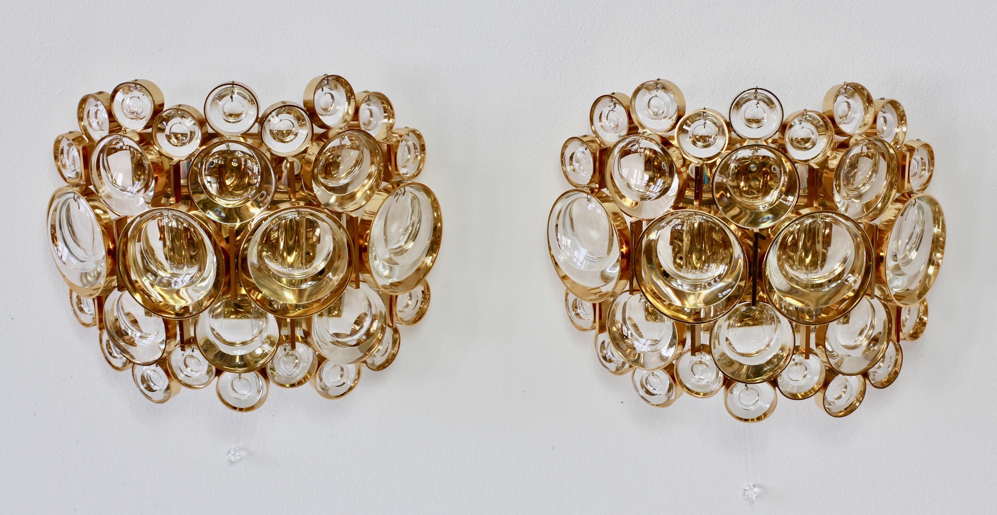 Stunning vintage midcentury pair of gilt brass and crystal glass wall-mounted lights, lamps or vanity sconces by Palwa, Germany, circa 1965-1975. Perfect for the Hollywood Regency style, there is no better combination than gold and crystal glass for