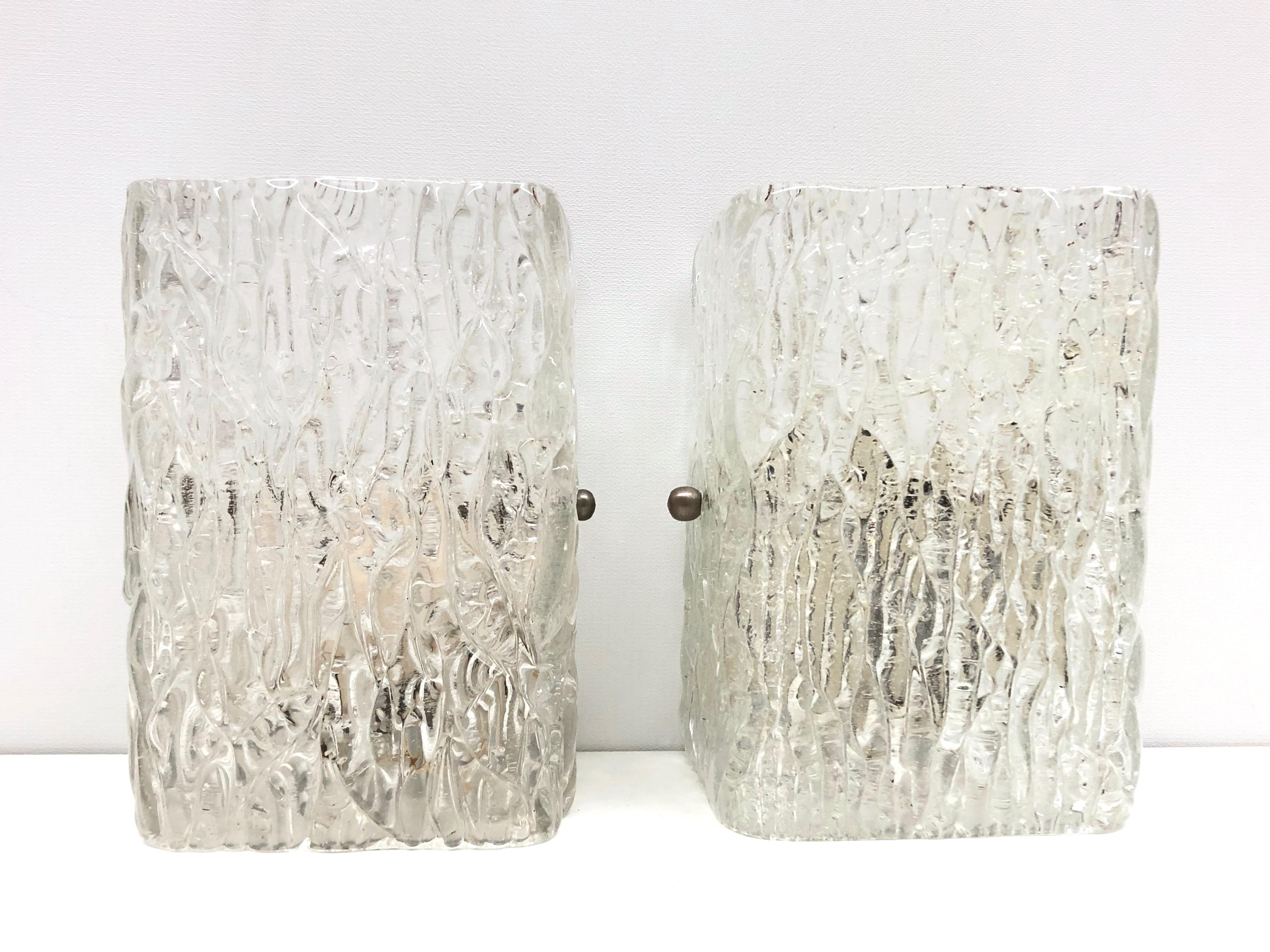 A stunning pair of Murano glass ice block wall sconces. Each consisting of a stylish single ice block design. A single white lacquered wall plate with a solo socket and mount make for a beautiful wall light. Easy to mount and fantastic to look at.