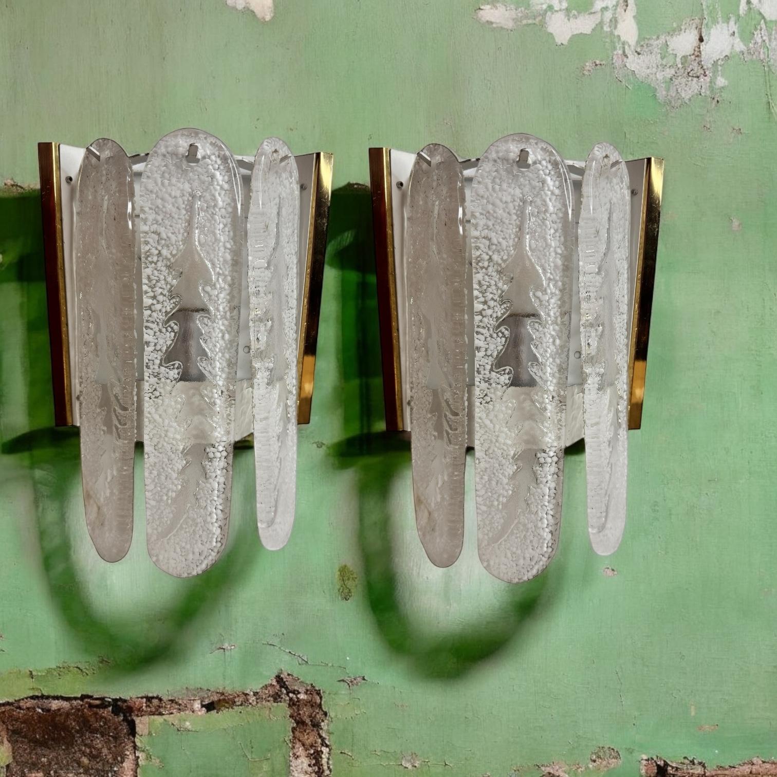 Une superbe paire d'appliques murales en verre de Murano. Chacun d'entre eux est doté d'un design élégant. Une simple plaque murale laquée blanche avec une douille solo et une monture constituent une belle applique murale. Facile à monter et