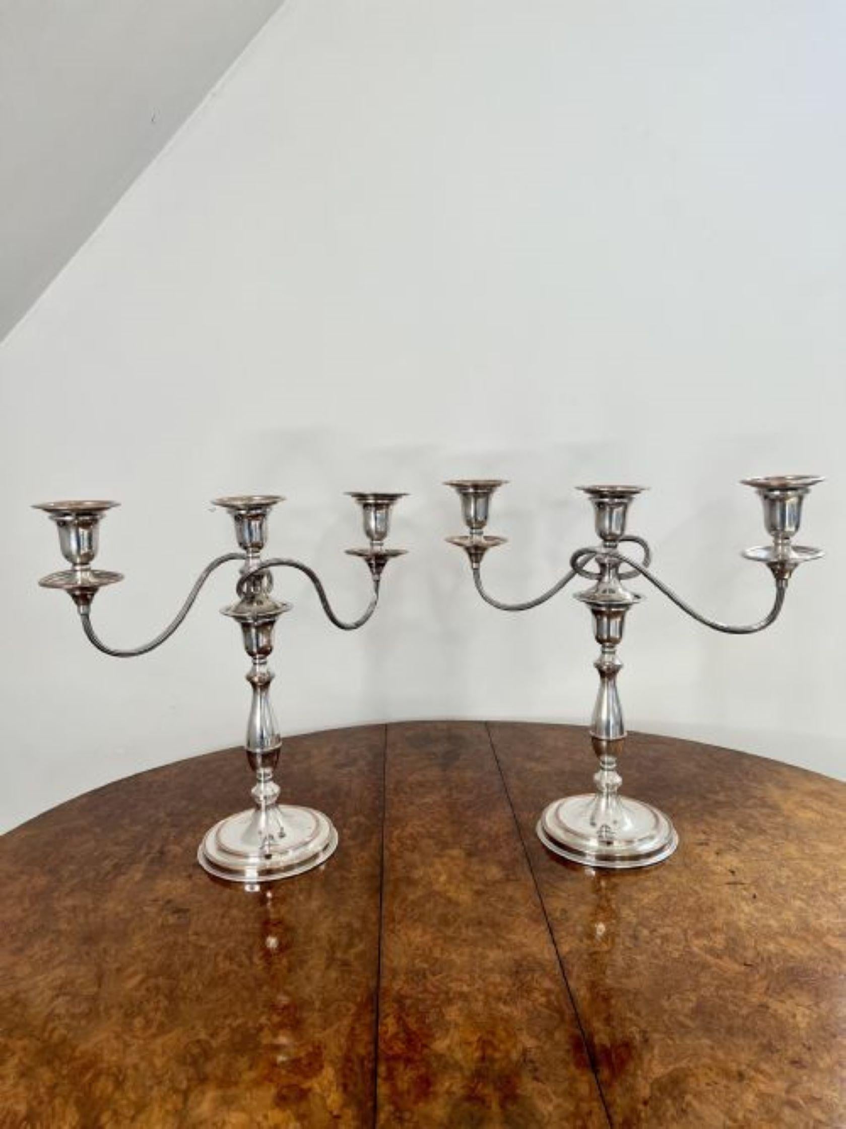 Stunning pair of quality antique Edwardian silver plated candelabras having a stunning pair of antique Edwardian silver plated candelabras with three light branches above a shaped column standing on circular bases.