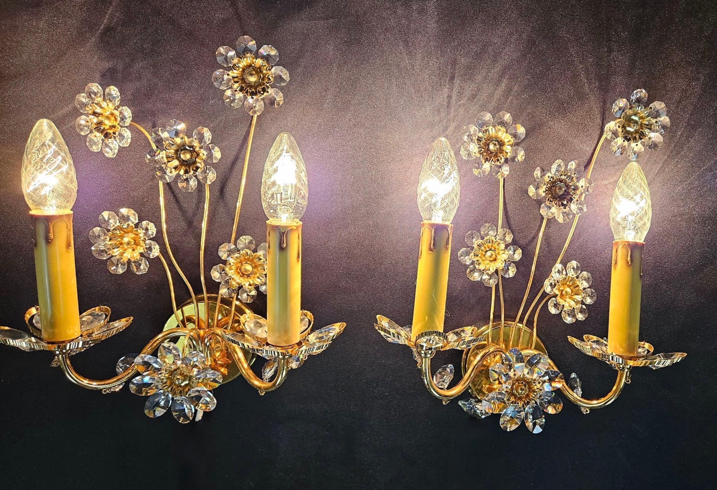 Pair of vintage gold-plated sconces with faceted crystal flowers made by the German company Palwa. Each fixture has two European style E14 socket. The Fixture requires two European E14 / 110 Volt Candelabra bulbs, each bulb up to 40 watts.
