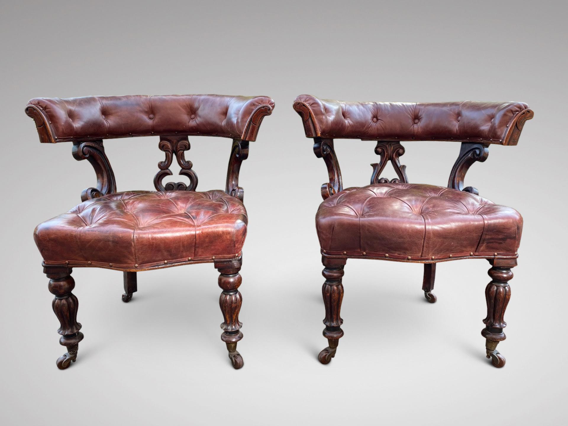 A stunning pair of William IV period leather and mahogany framed desk or library chairs with horse shoe back rest terminating in carved mahogany scroll ends. The back rest is upheld by a central splat also two angled carved mahogany supports, which