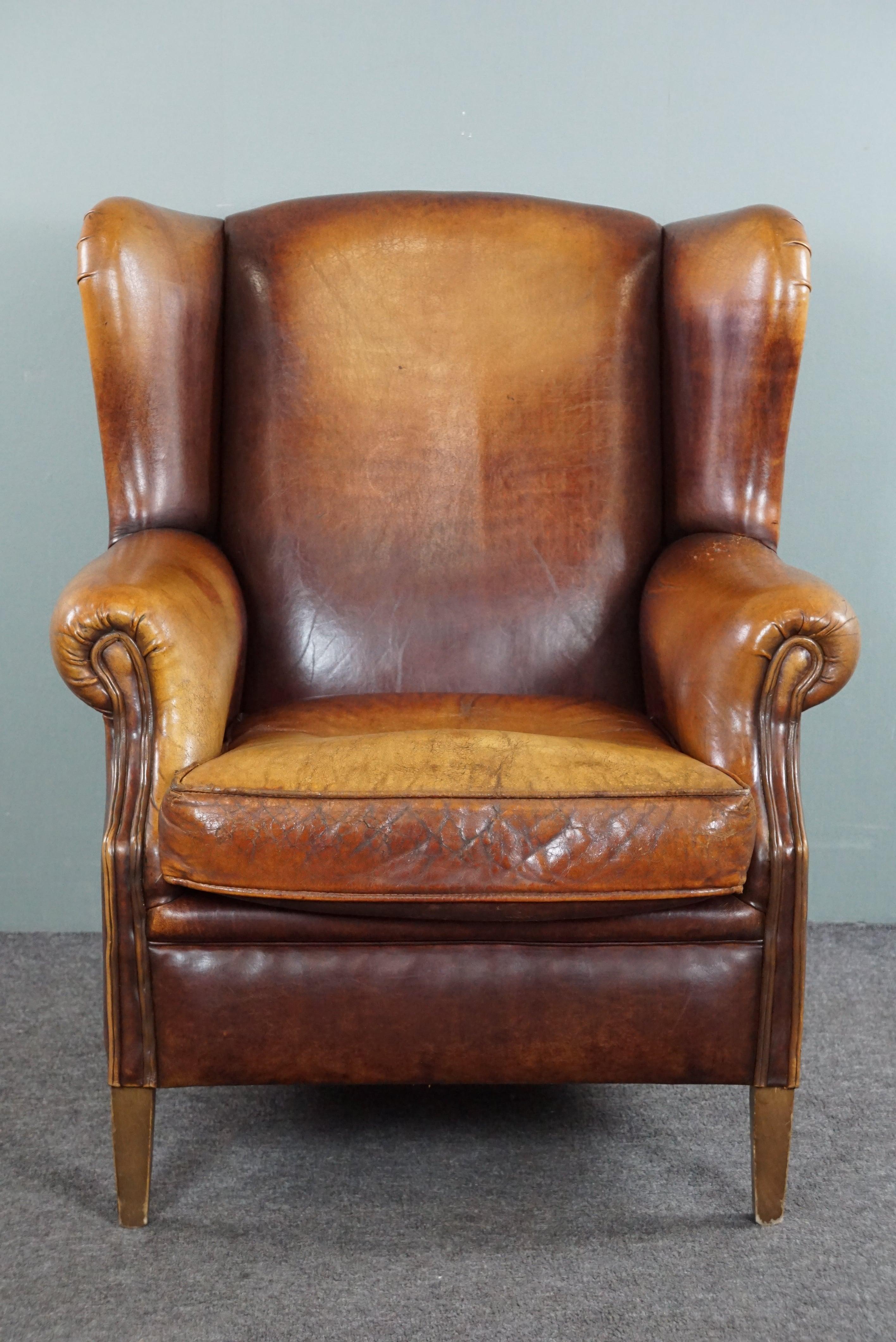 Offered is this beautiful worn sheepskin leather wing chair in a great color scheme!

This striking wing chair with a lived-in look has a beautiful variety of colors in the sheep leather. Through use, this armchair has acquired a beautiful character
