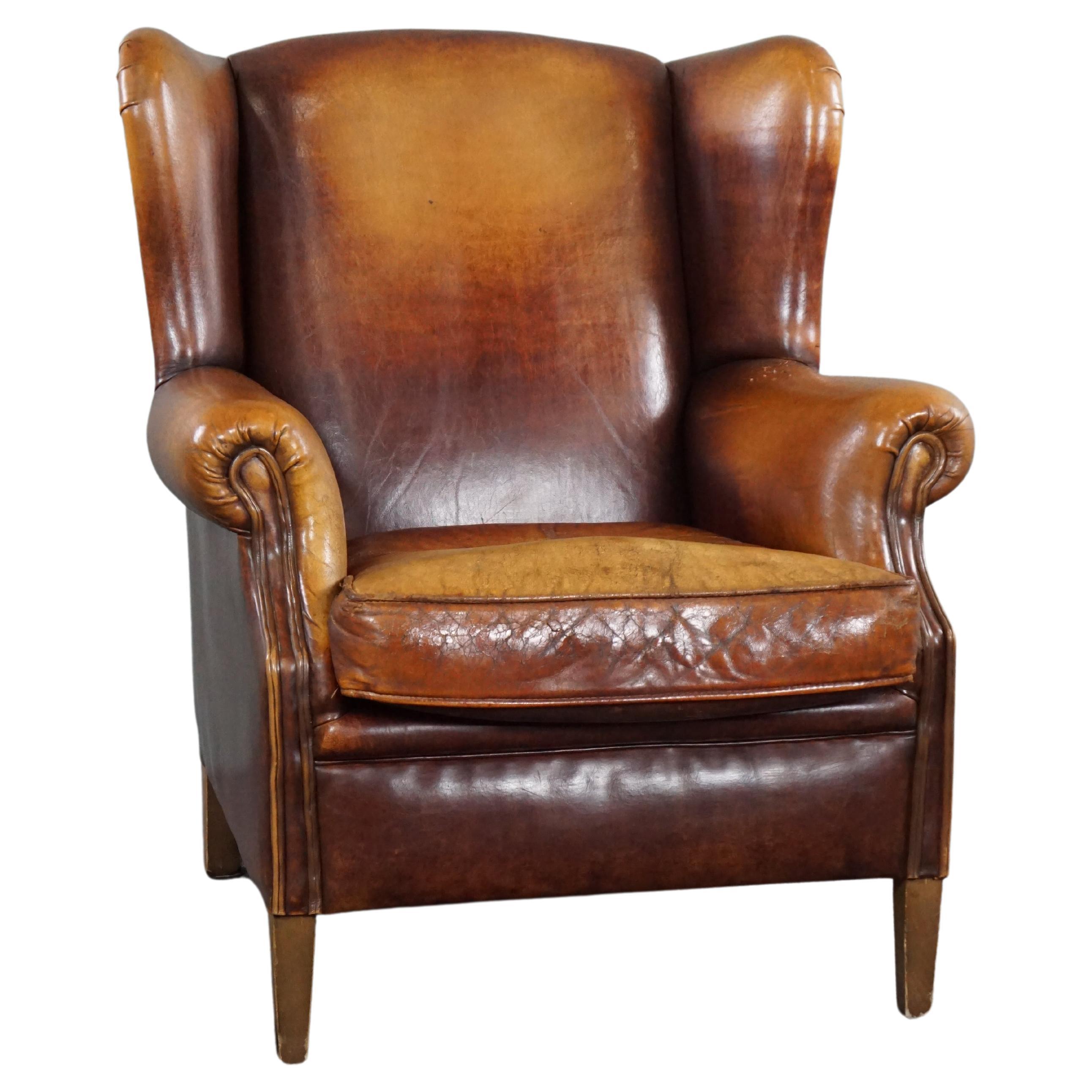 Stunning patinated sheepskin leather wing chair For Sale