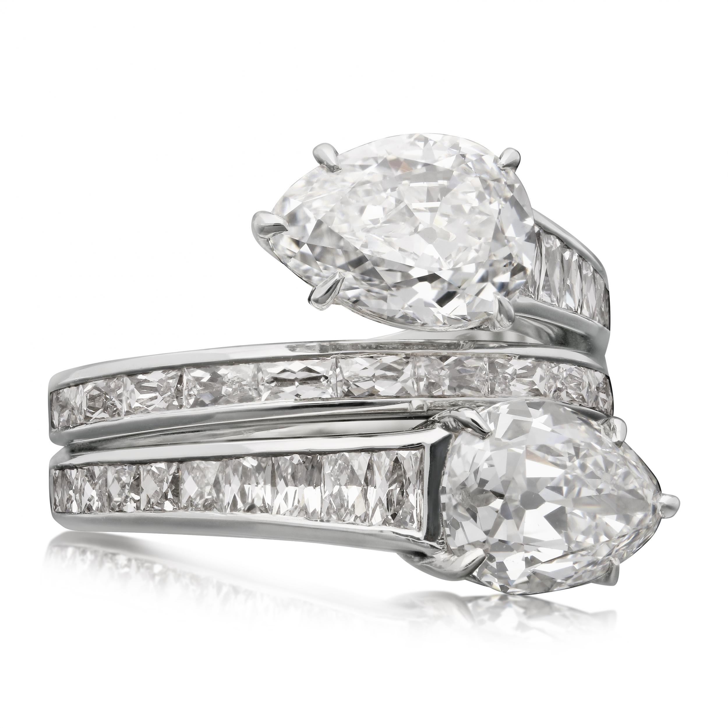 Description
A stunning old cut pear shaped diamond cross over ring by Hancocks, the double wrap-around band finely hand crafted in platinum and set with calibre-cut French cut diamonds in a channel setting, the outer edges set with a row of round