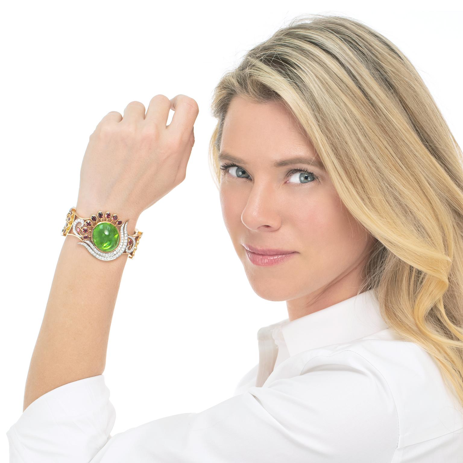 Circa 1980s, 18k, Swiss. This brilliantly colorful bracelet features a superb one-of-a-kind design and sublime stones. A massive 70 carat peridot is the visual center of the bracelet with diamonds sweeping around one side and uniquely hued