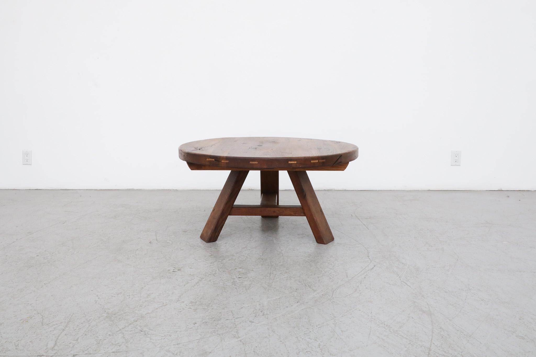This handsome, Brutalist, Pierre Chapo inspired coffee or side table is made from solid oak with a generous round top and attractive tripod trestle base. The piece is in original condition with some visible wear, including some natural cracking.