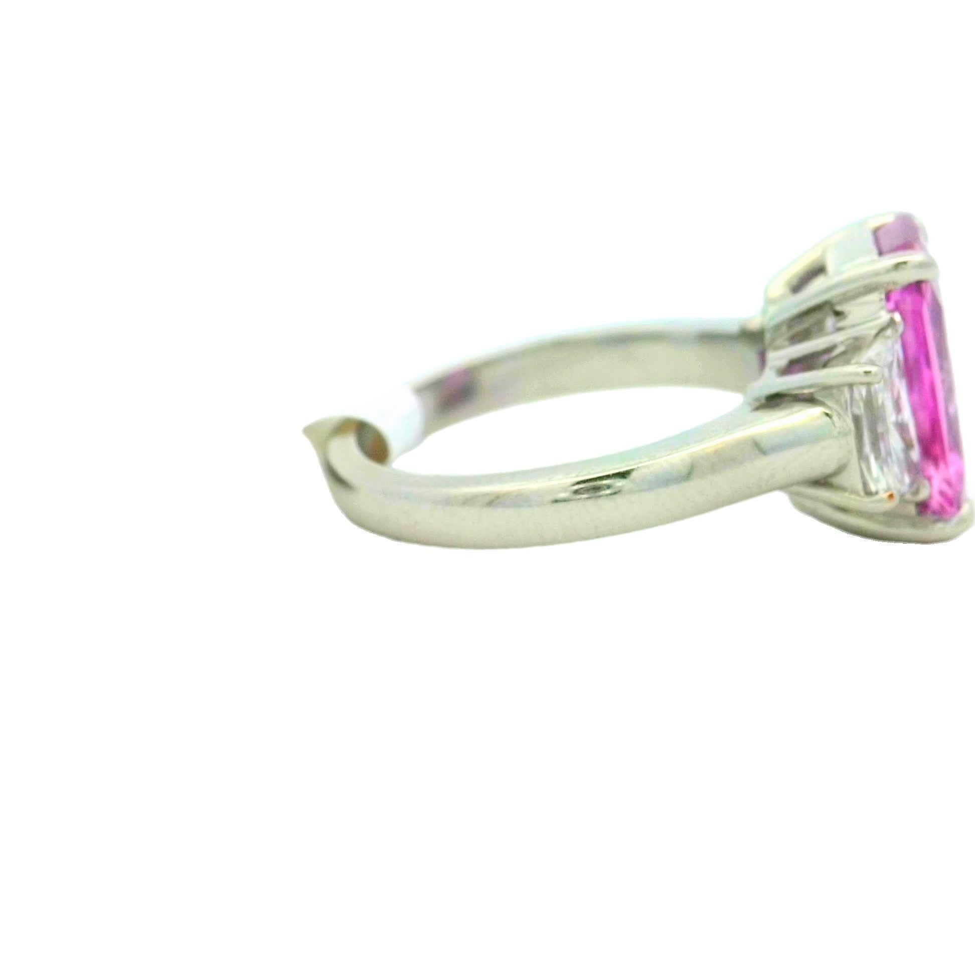 This exquisite ring features a vibrant pink gemstone at its center, flanked by two sparkling diamonds. Crafted with precision, it showcases a perfect blend of elegance and modern design, making it a standout piece for any jewelry collection.