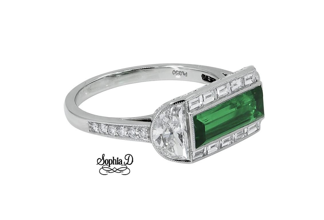 Exquisite ring set in platinum by Sophia D with emerald center stone in baguette cut weighing 1.10 carats surrounded by two beautiful side half moon diamonds weighing 0.89 carats and small diamonds weighing 0.24 carats.

Ring is available for