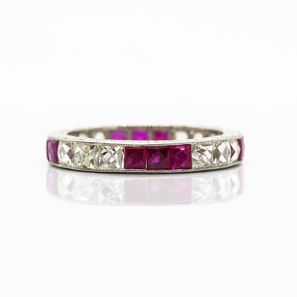 This exquisite ring exhibits 12 French cut diamonds of H-VS2 quality that weigh 2.10ctw.
The glowing diamonds are interspersed with 12 natural French cut rubies that weigh 2.20ctw.
This stunning piece of jewelry was crafted in solid platinum.
This