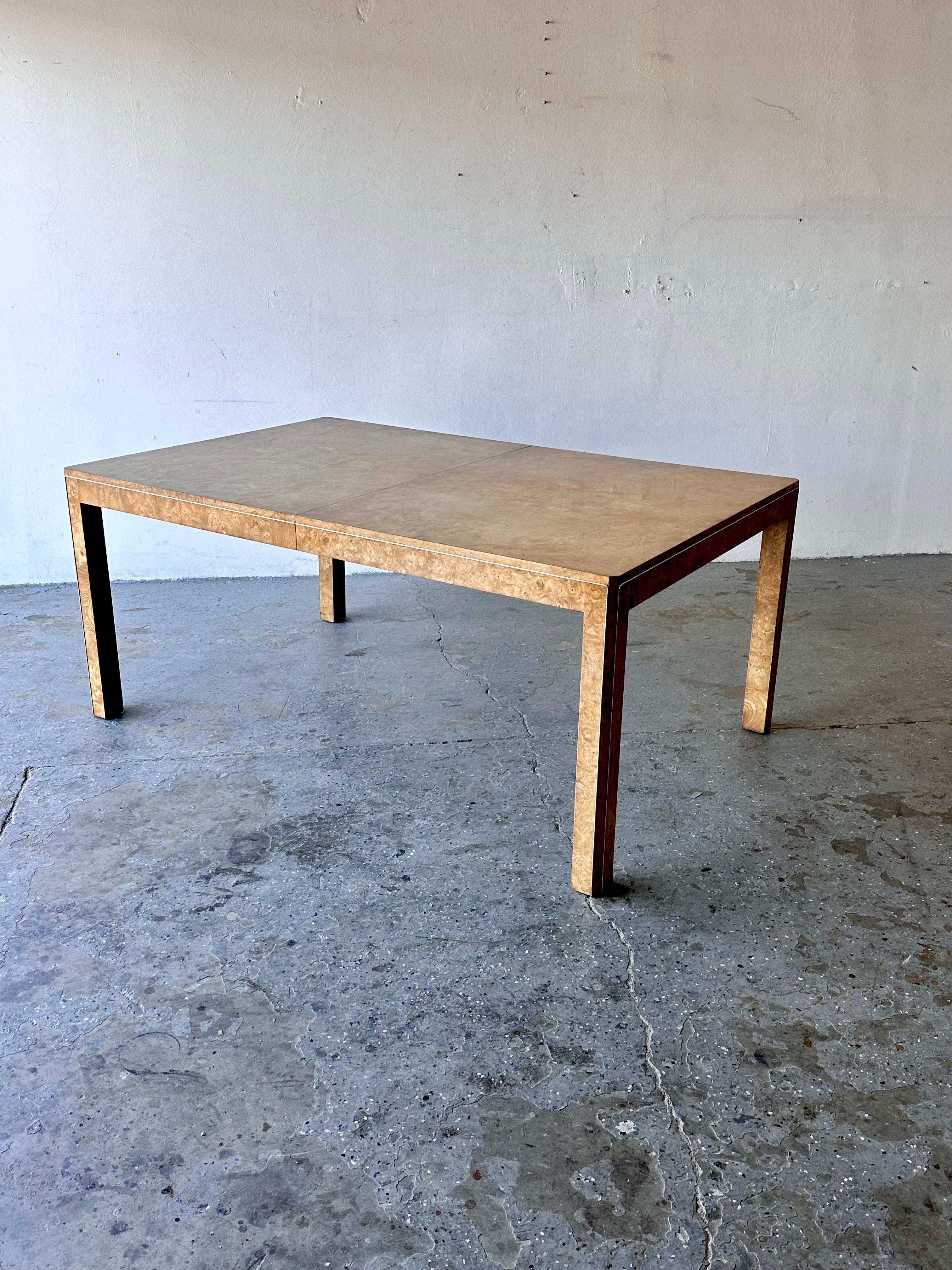 Stunning Olive Burl Wood: The table showcases the unique and intricate grain patterns of olive burl wood, bringing a touch of natural beauty and warmth to your dining space.

Elegant Brass Trim: Accentuated with brass trim, this table exudes