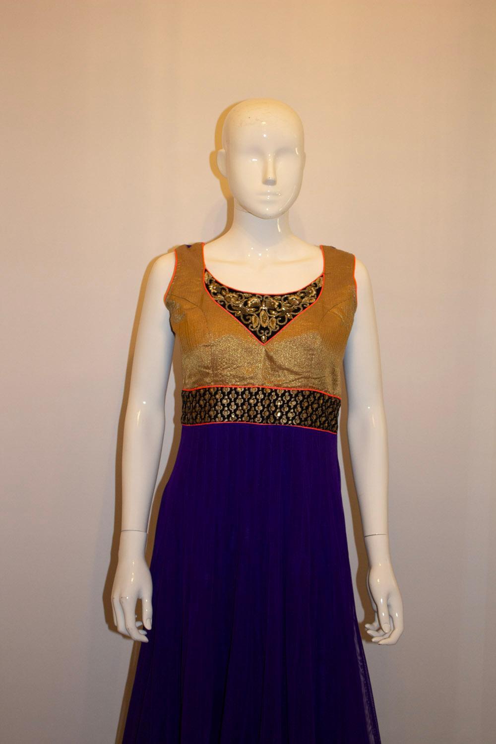 A headturning and easy to wear Indian dress. The dress is in a glorious combination of gold and purple. It has  a side zip opening and tie detail at the back. 
Measurements: Bust up to 38'', length 50''