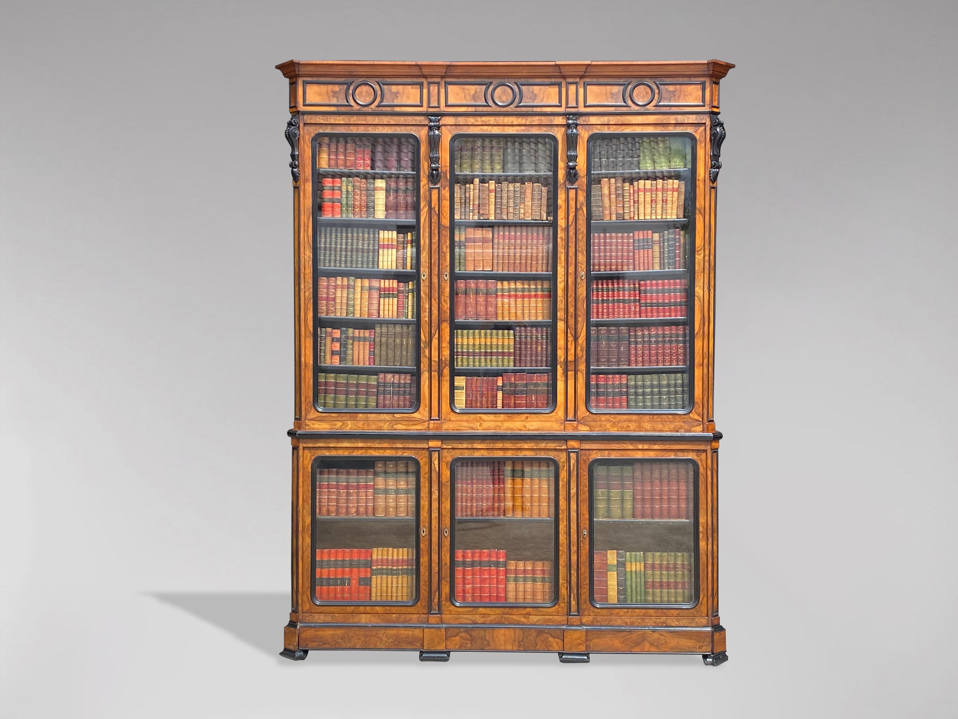 A superb quality and exceptional French mid-19th century solid walnut and ebonized three door bibliotheque or library bookcase. With tall moulded cornice above three ebonized trim glazed doors enclosing five solid adjustable shelves with black
