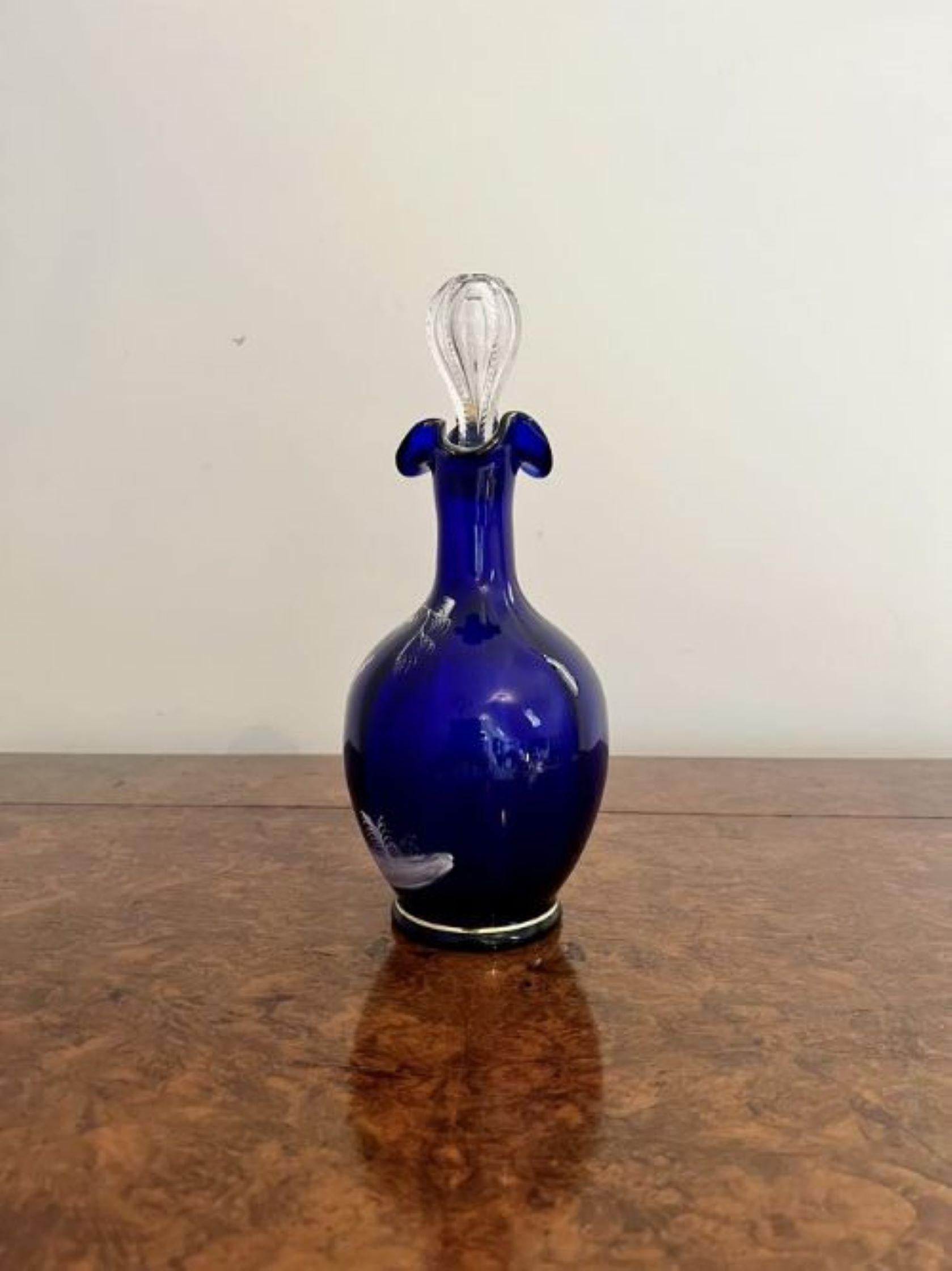 Stunning quality antique Mary Gregory blue glass decanter having a stunning quality Mary Gregory blue glass decanter with white enamel decoration and gold gilding with a shaped handle to the back and a wavy top with the original glass stopper.