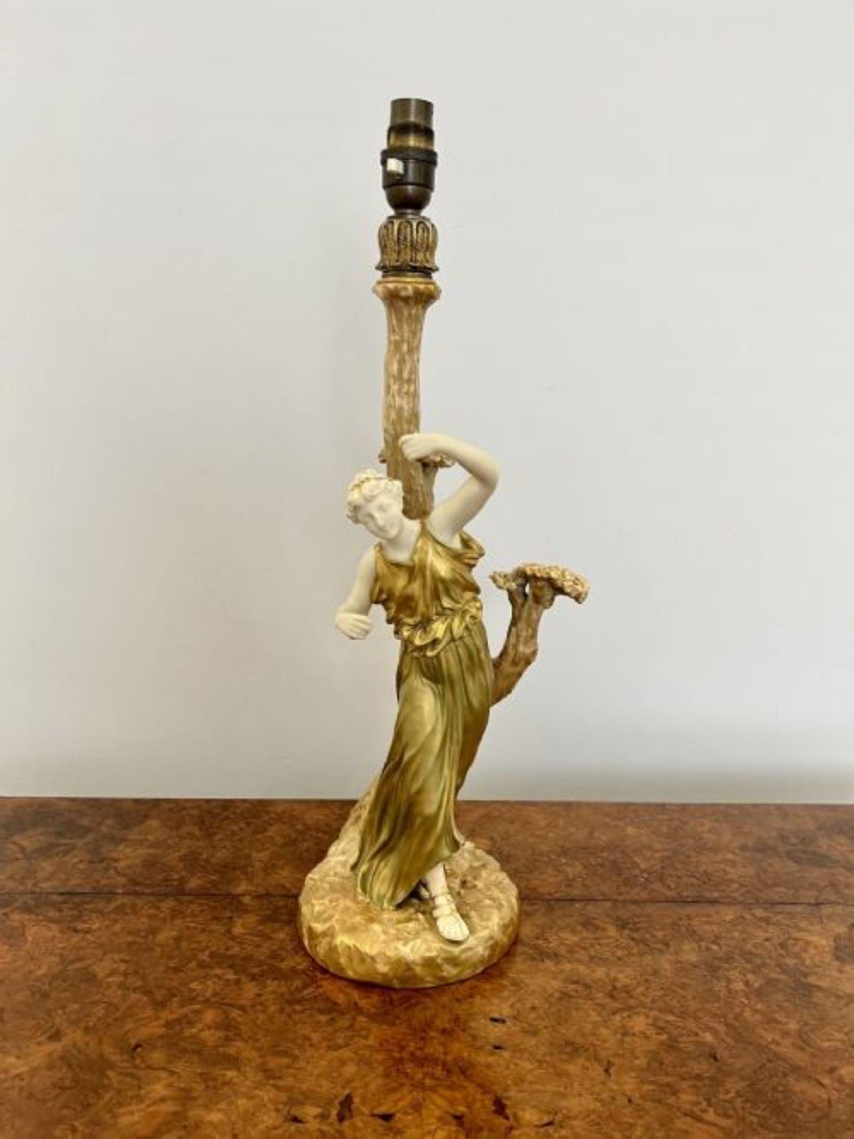 Stunning quality antique Royal Worcester table lamp having a quality antique Royal Worcester table lamp of a lady wearing a gold dress with a matching gold head piece and gold sandals standing on a circular base with a tree stump to the back