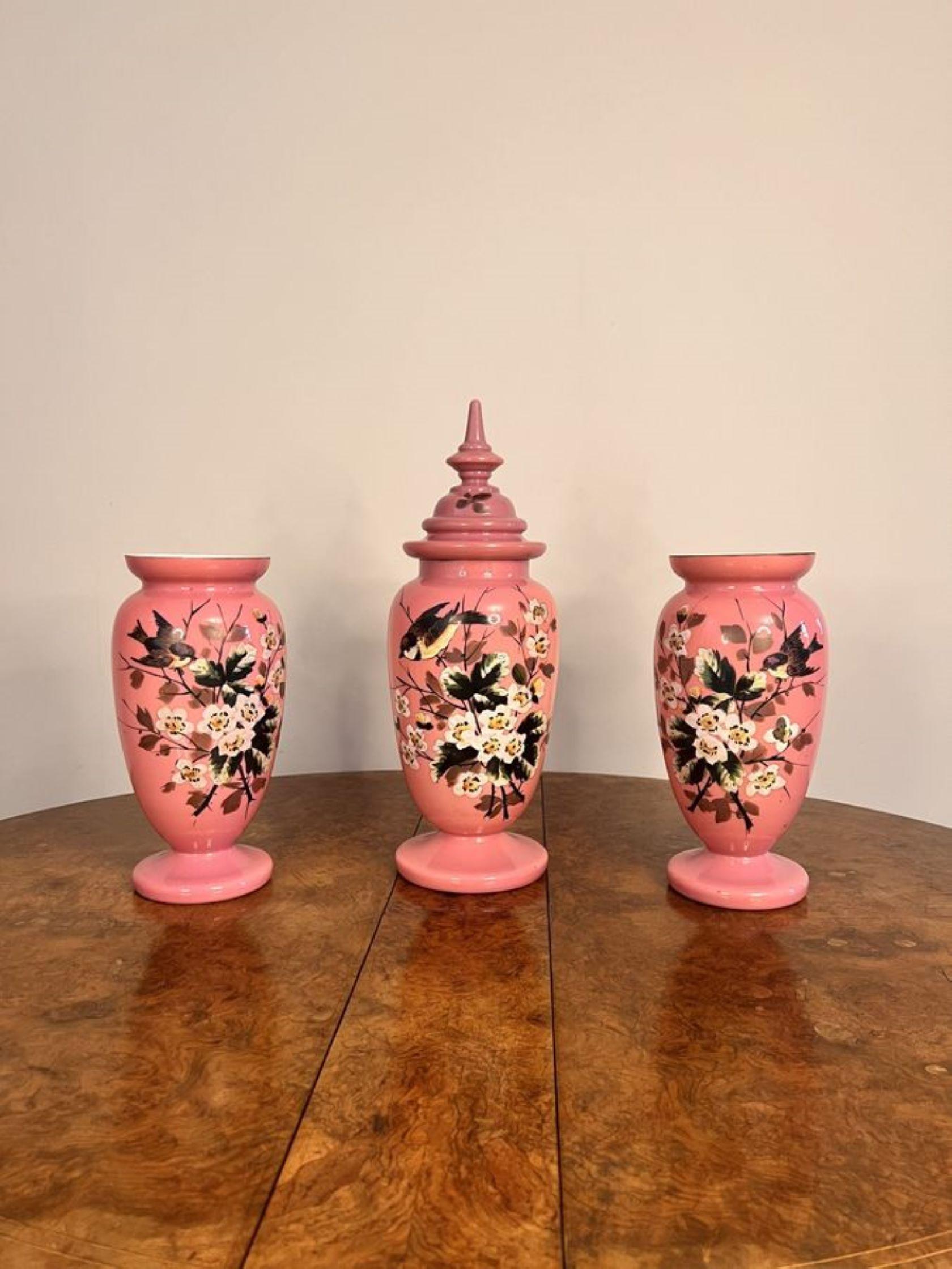 Stunning quality antique Victorian garniture of glass vases, consisting on three quality antique pink glass vases, having a centre lidded vase with two open top vases, fantastic hand painted decorated with birds and flowers in wonderful green,