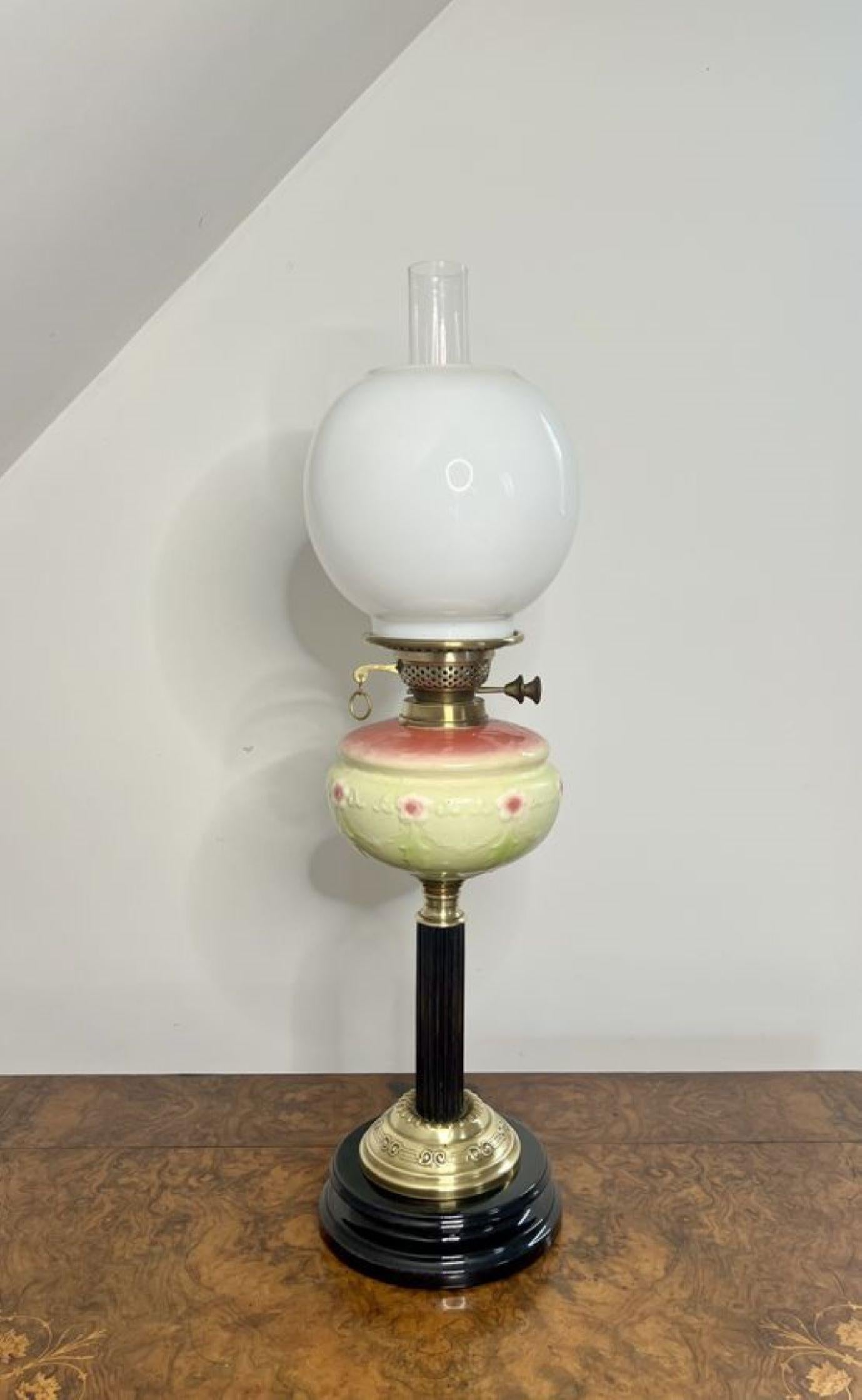 Stunning quality antique Victorian oil lamp having a quality brass oil lamp with a white glass globular shade, having a vaseline glass reservoir with a yellow ground and pink flowers, supported on a wooden column, raised on a circular brass base.
