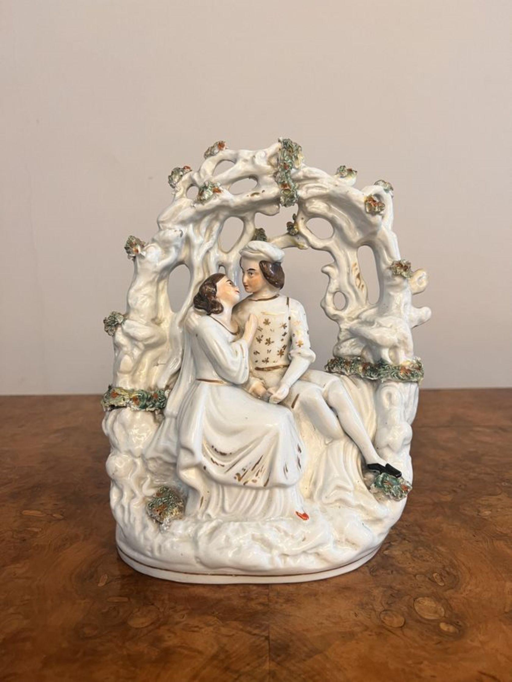 Stunning quality antique Victorian Staffordshire figure, having a quality Staffordshire figure of a man and woman seated in traditional clothing surrounded by foliage, hand painted in white, green and brown colours with gold gilded detail, raised on