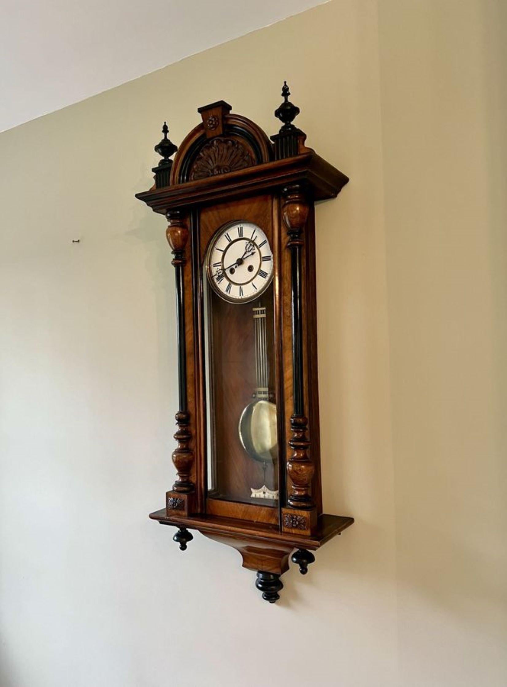 Stunning quality antique Victorian walnut Vienna wall clock having turned columns, original finale's with a shaped top and bottom. Single walnut glazed door opening to reveal a circular porcelain dial with the original hands with Roman numerals