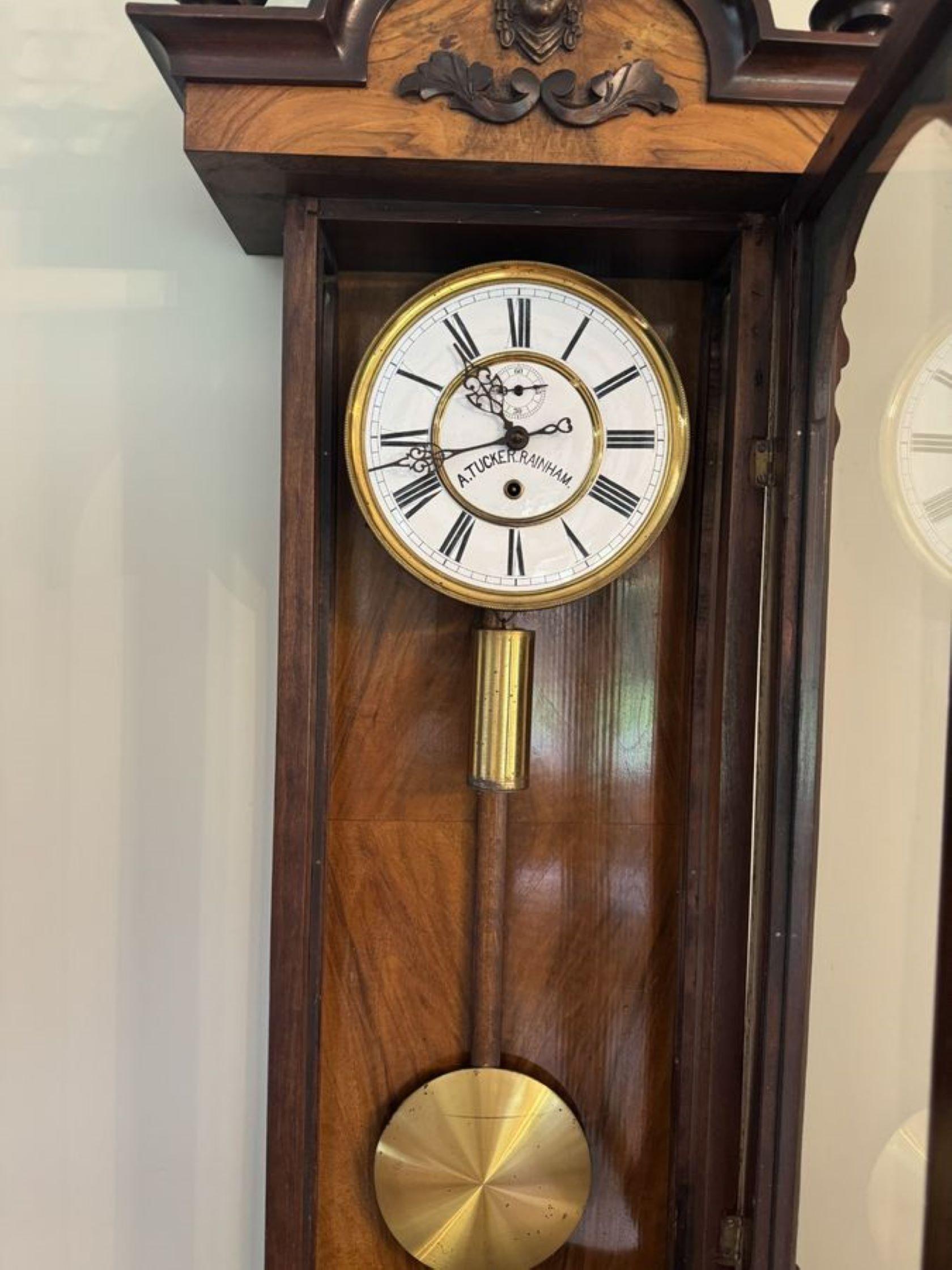 Stunning quality antique Victorian walnut Vienna wall clock having turned columns, the original finale's with a wonderful shaped top mounted with carved leaves and a shaped bottom. Single walnut glazed door opening to reveal a circular white enamel