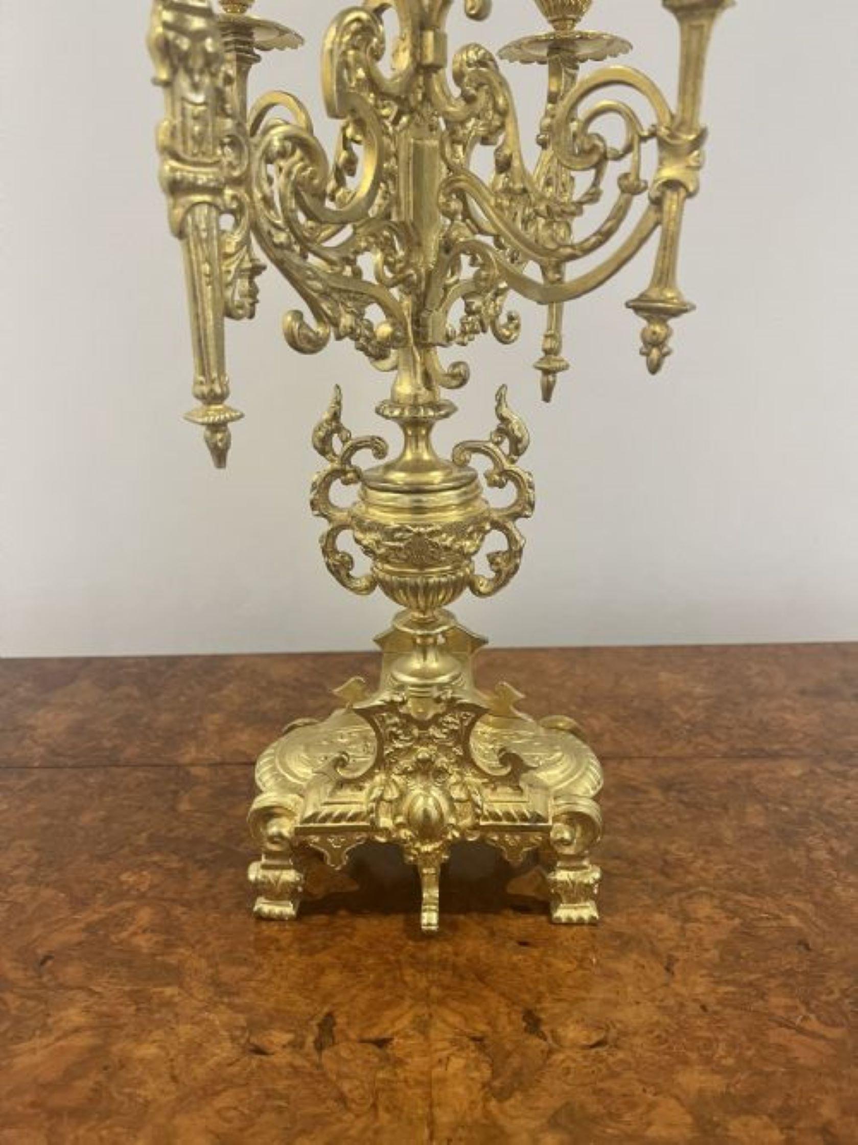 Stunning quality French antique Victorian ornate brass clock garniture having a quality Victorian ornate brass clock garniture comprising of a fantastic pair of five light candelabras the clock itself having a white porcelain dial with the original